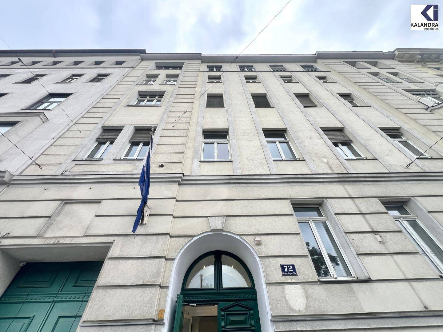 Fassade eines klassischen Altbaus mit vielen Fenstern und einem markanten Eingangsbereich.