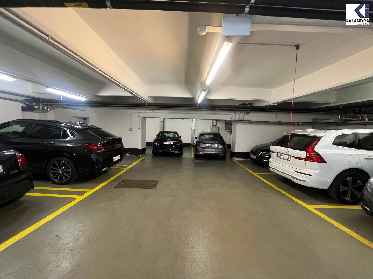 Tiefgarage mit mehreren geparkten Fahrzeugen und ausreichender Beleuchtung.