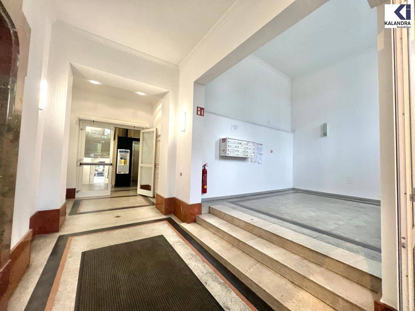 Geräumiger Eingangsbereich mit Marmorboden und Treppe, die zu den oberen Etagen führt.