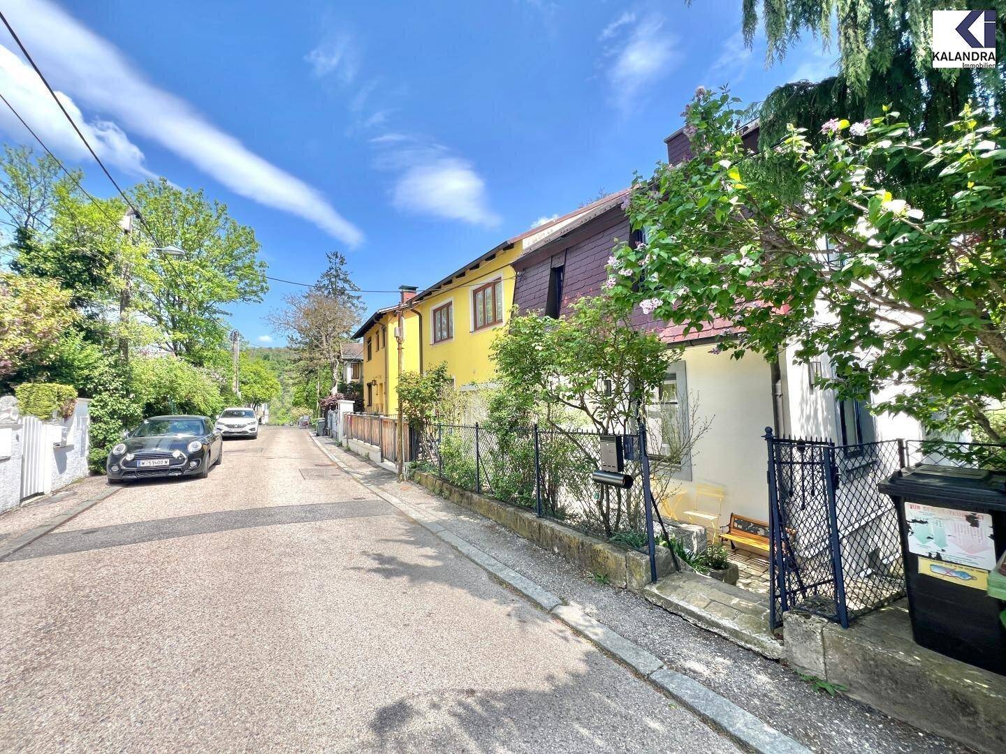 Ruhige Wohnstraße mit charmanten Häusern und viel Grün, die eine ländliche Atmosphäre schafft.