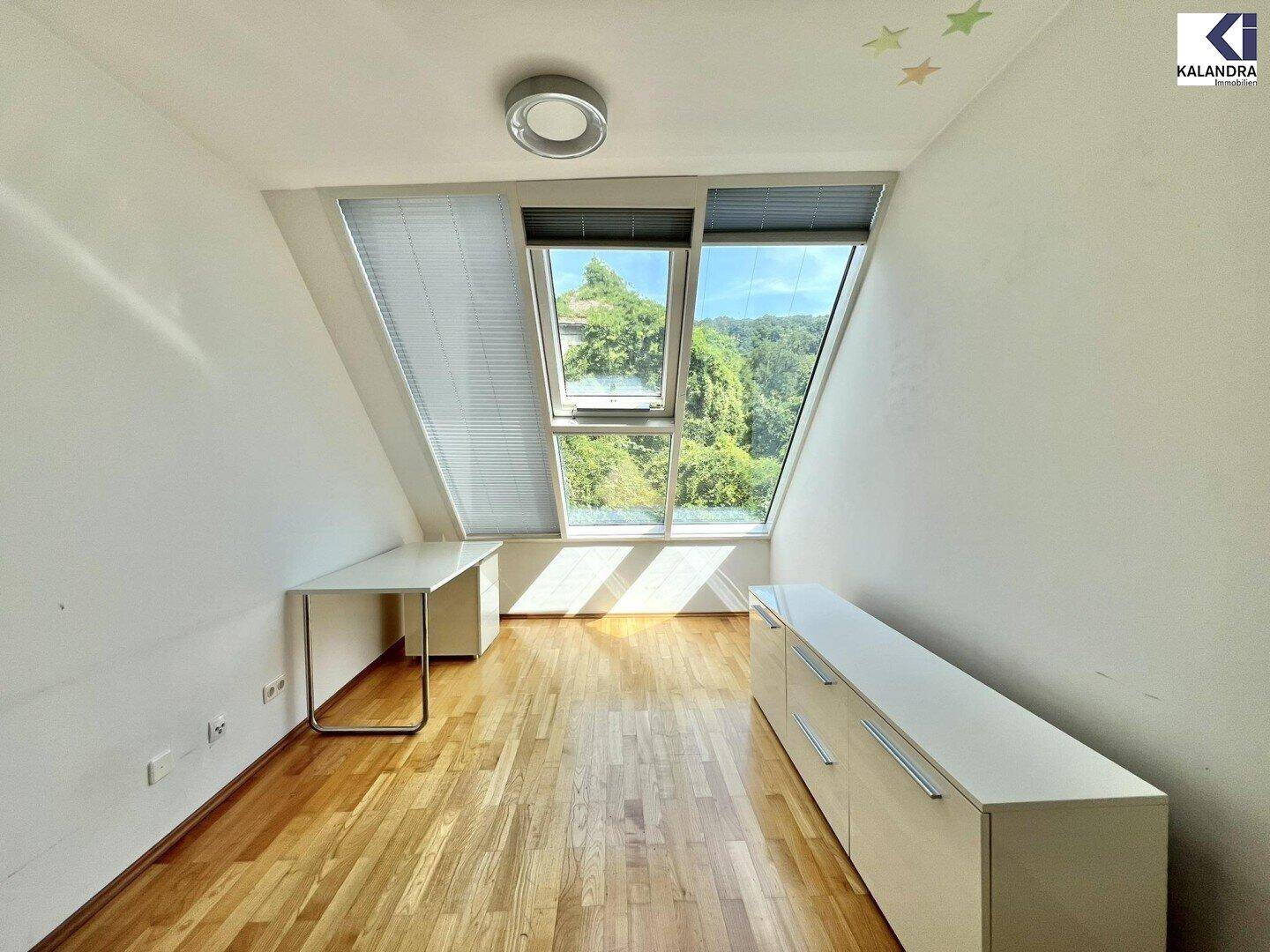 Modern eingerichtetes Zimmer im Dachgeschoss mit Schreibtisch und Schrank, ideal als Arbeits- oder Kinderzimmer.