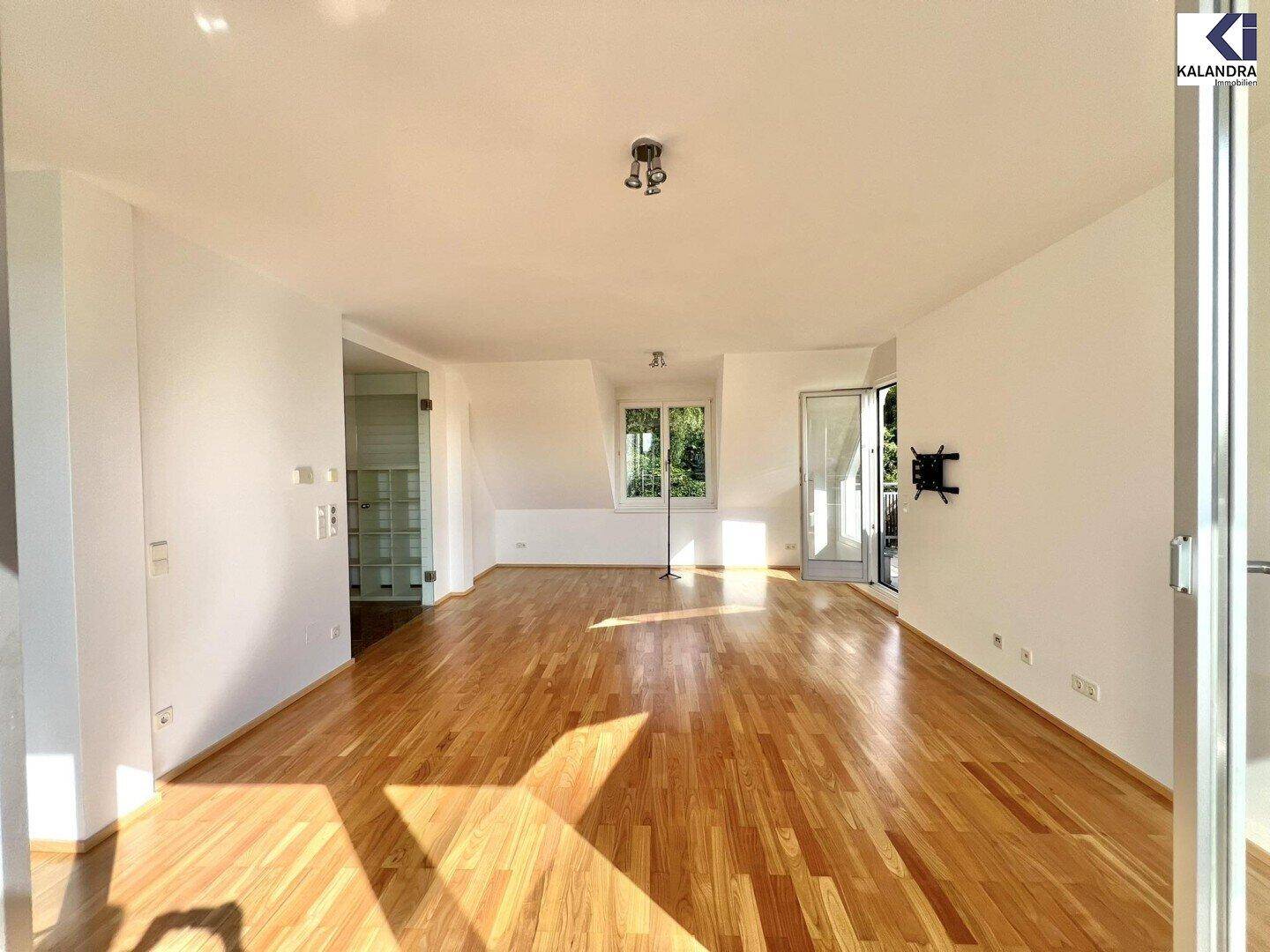 Großes, helles Wohnzimmer mit Holzboden und schrägen Wänden, bietet vielseitige Gestaltungsmöglichkeiten.