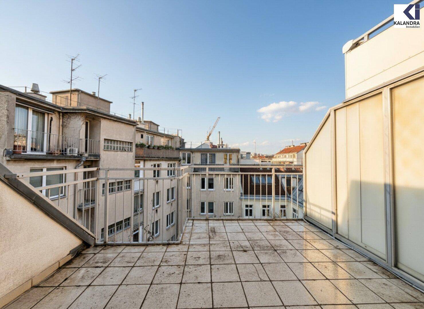 Geräumige Dachterrasse mit weitem Blick über die umliegenden Gebäude und Dächer der Stadt.
