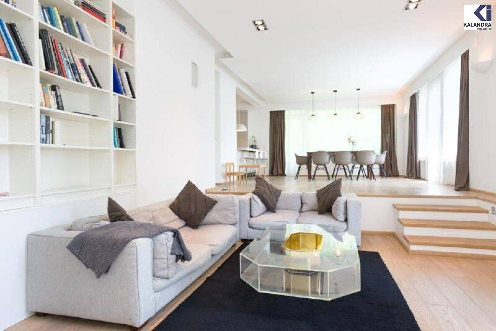Heller Wohnbereich mit Parkettboden, bequemen Sofas und integriertem Bücherregal.