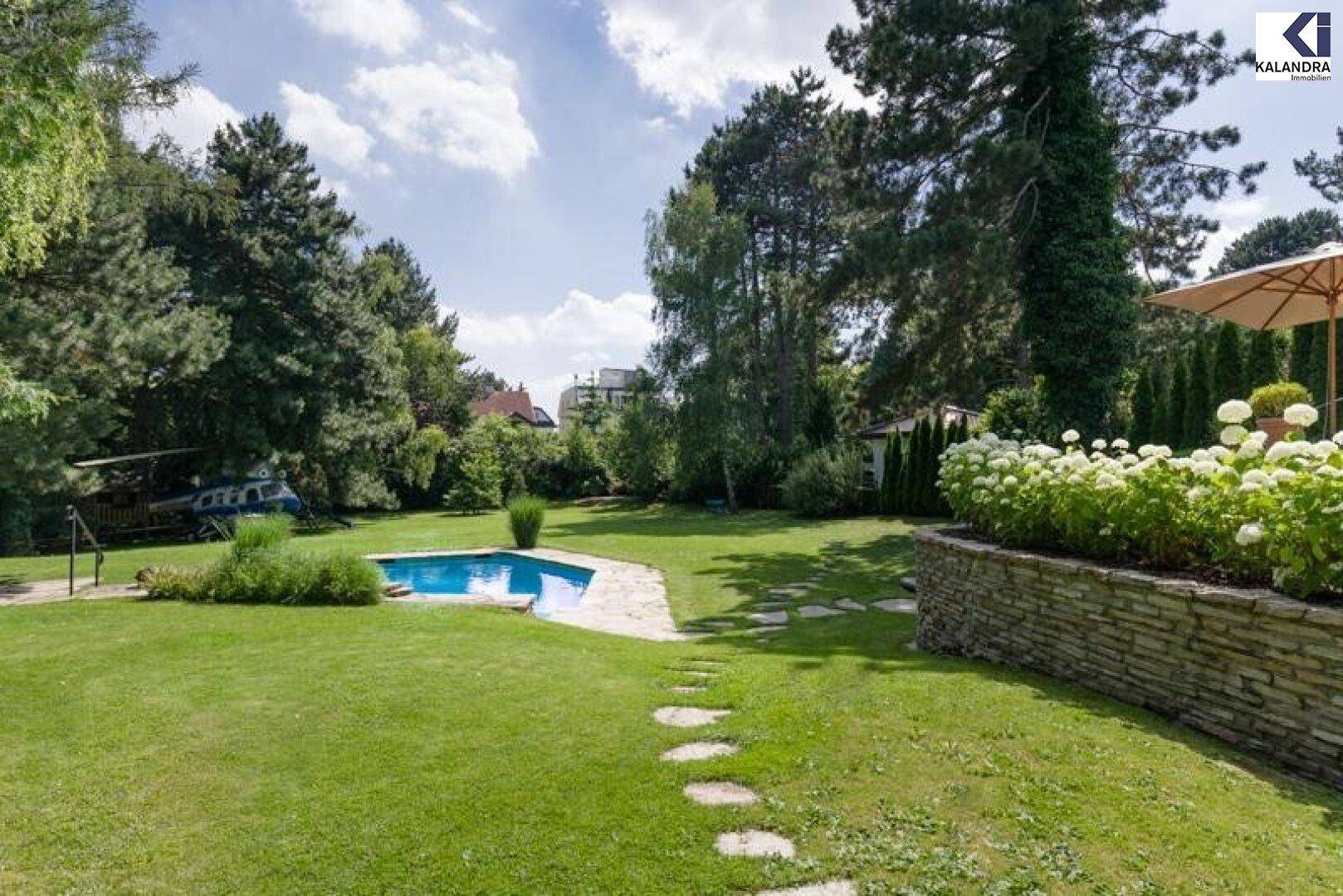 Weitläufiger Garten mit Swimmingpool, gepflegtem Rasen und altem Baumbestand.