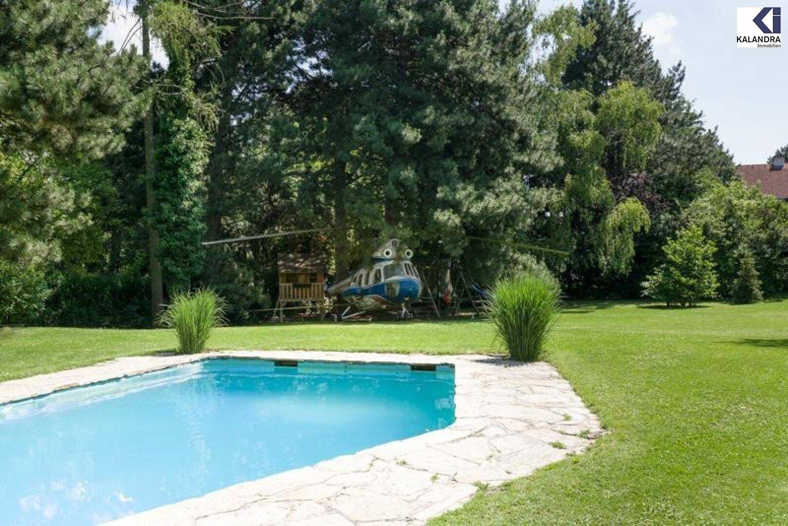 Garten mit Swimmingpool und weitem Blick auf die grüne Umgebung.