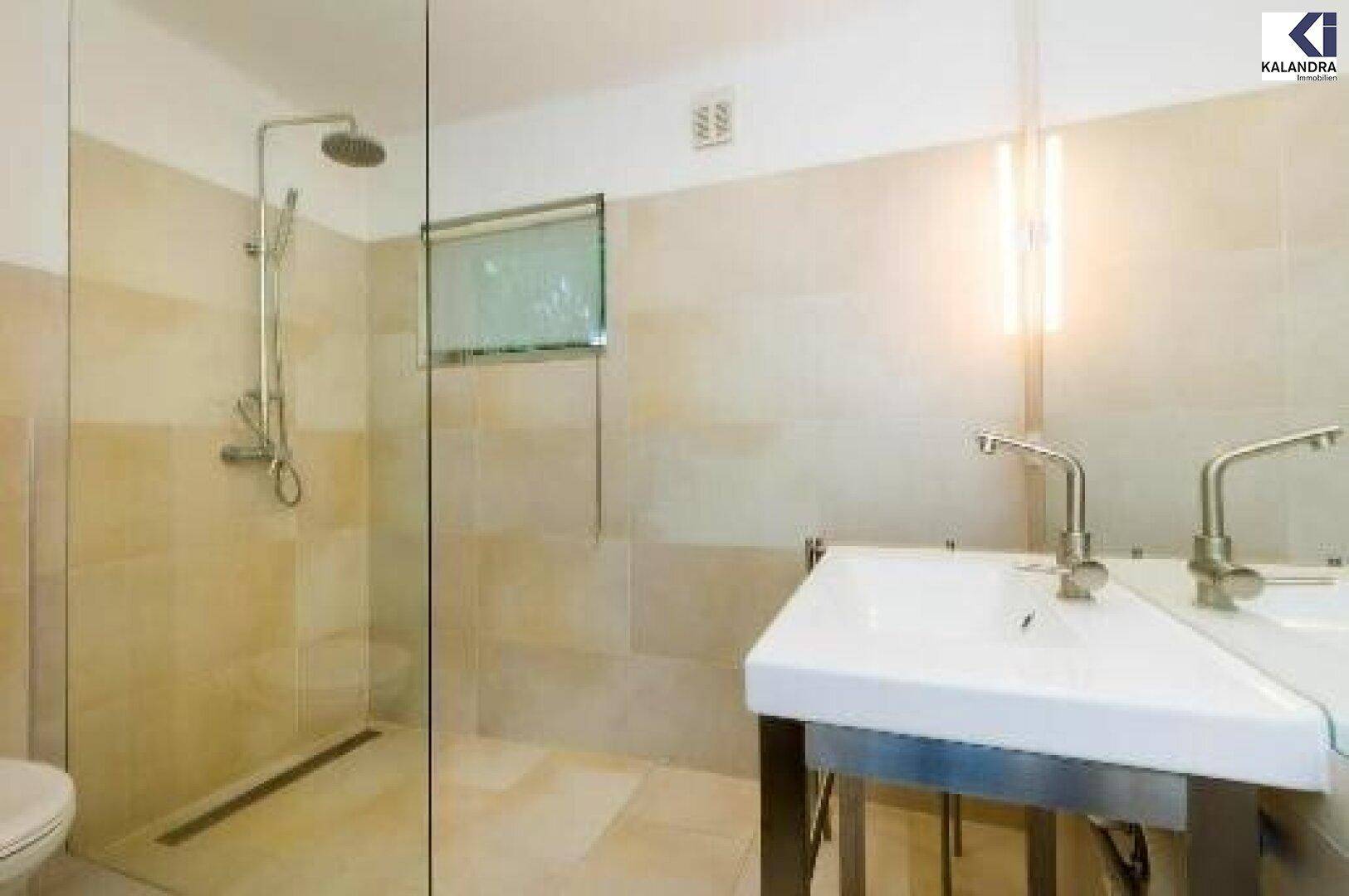 Modernes Badezimmer mit Doppelwaschbecken und ebenerdiger Dusche.