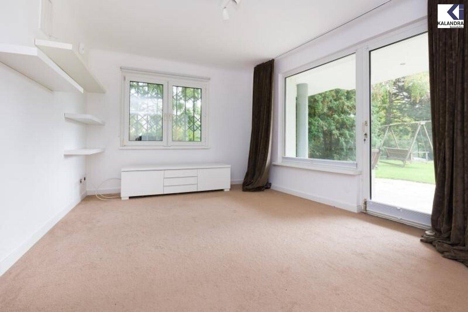 Geräumiges Schlafzimmer mit Teppichboden, Regalen und Zugang zum Garten.