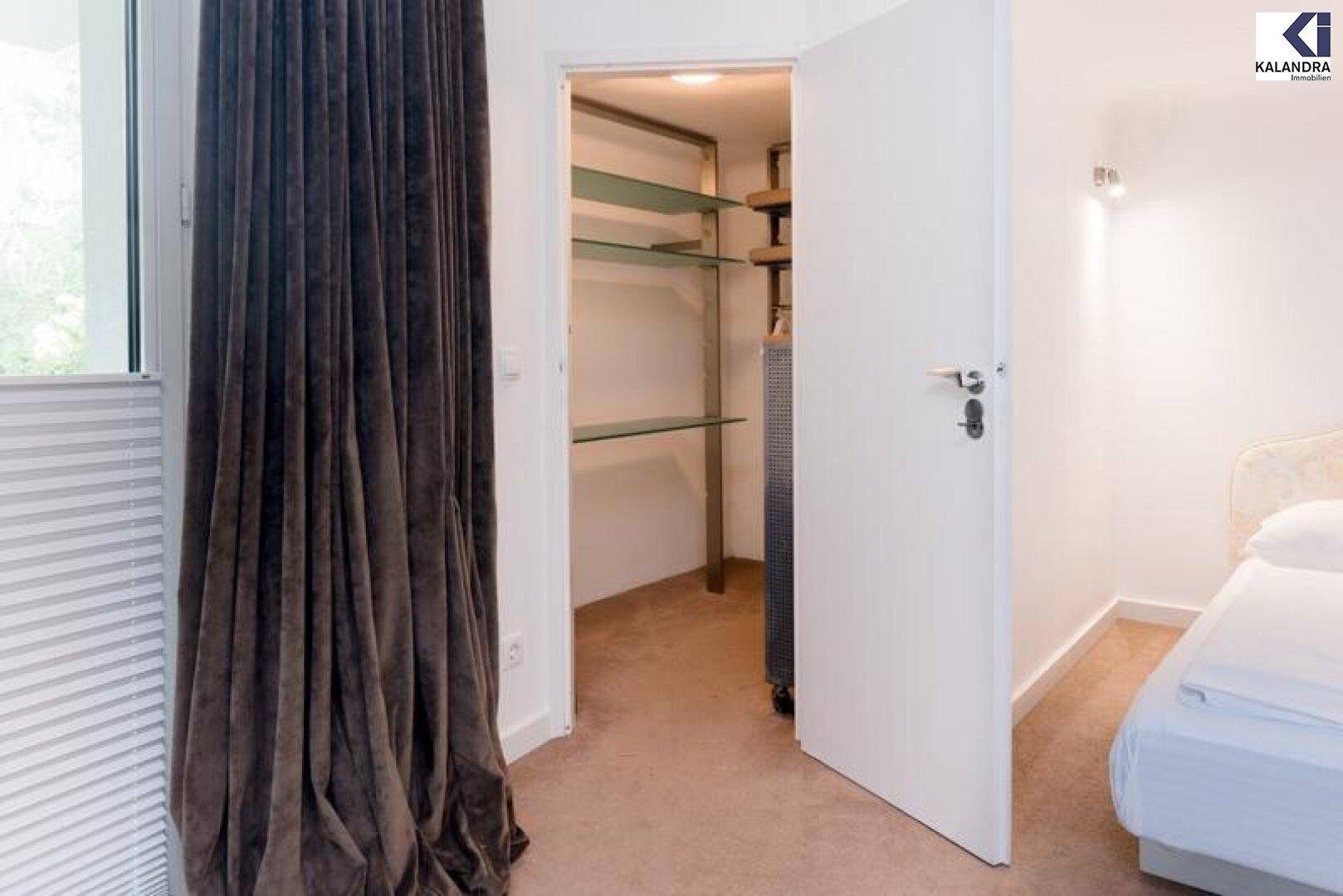 Begehbarer Kleiderschrank mit Regalen und Teppichboden.