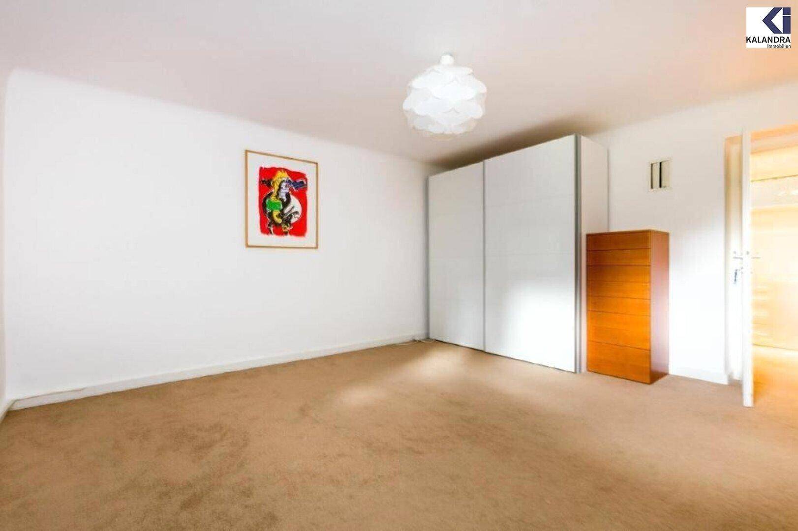 Geräumiges Schlafzimmer mit Teppichboden, Schrank und Fenster.