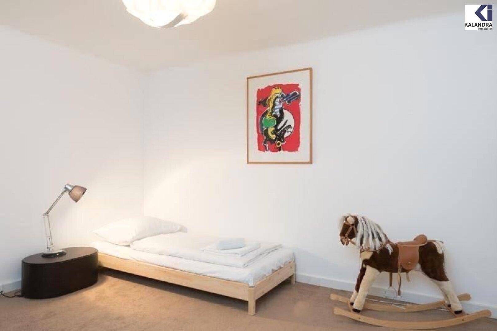 Kinderzimmer mit Einzelbett, Schaukelpferd und Teppichboden.