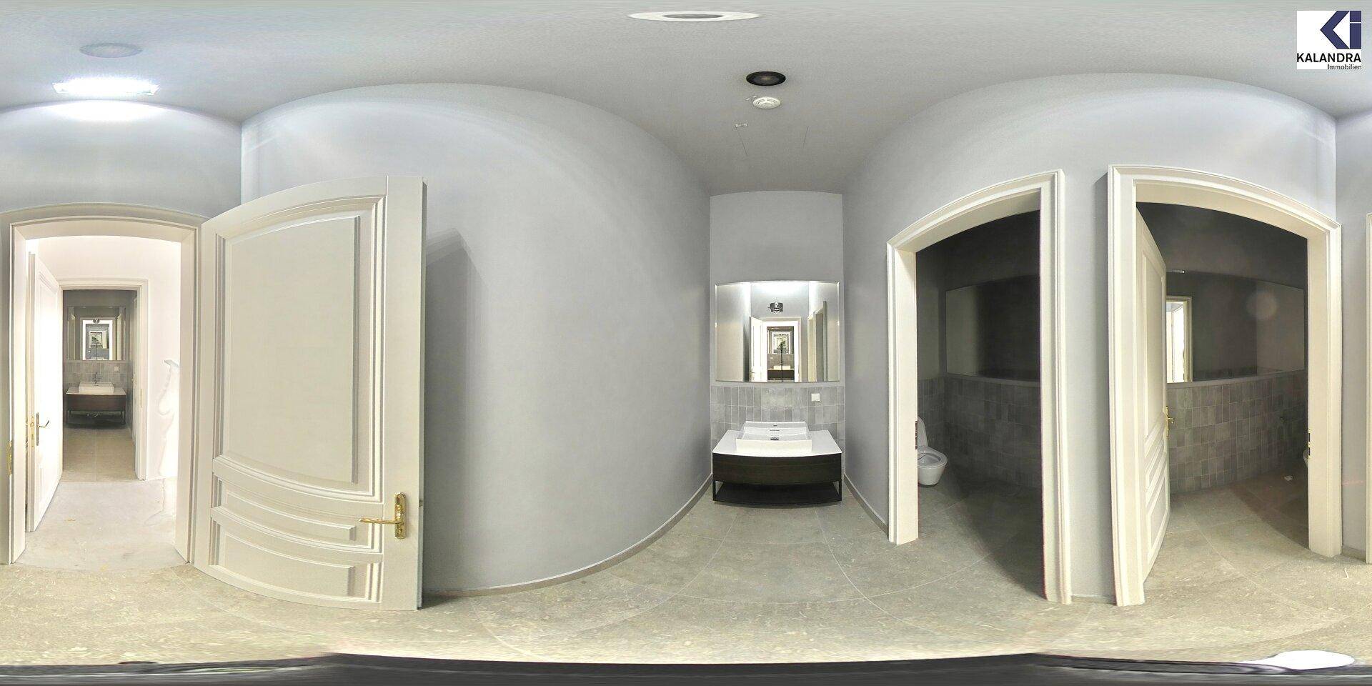 Modernes Badezimmer mit Waschtisch, Spiegel und Toilette, in hellgrauen Farbtönen und Fliesen gestaltet.