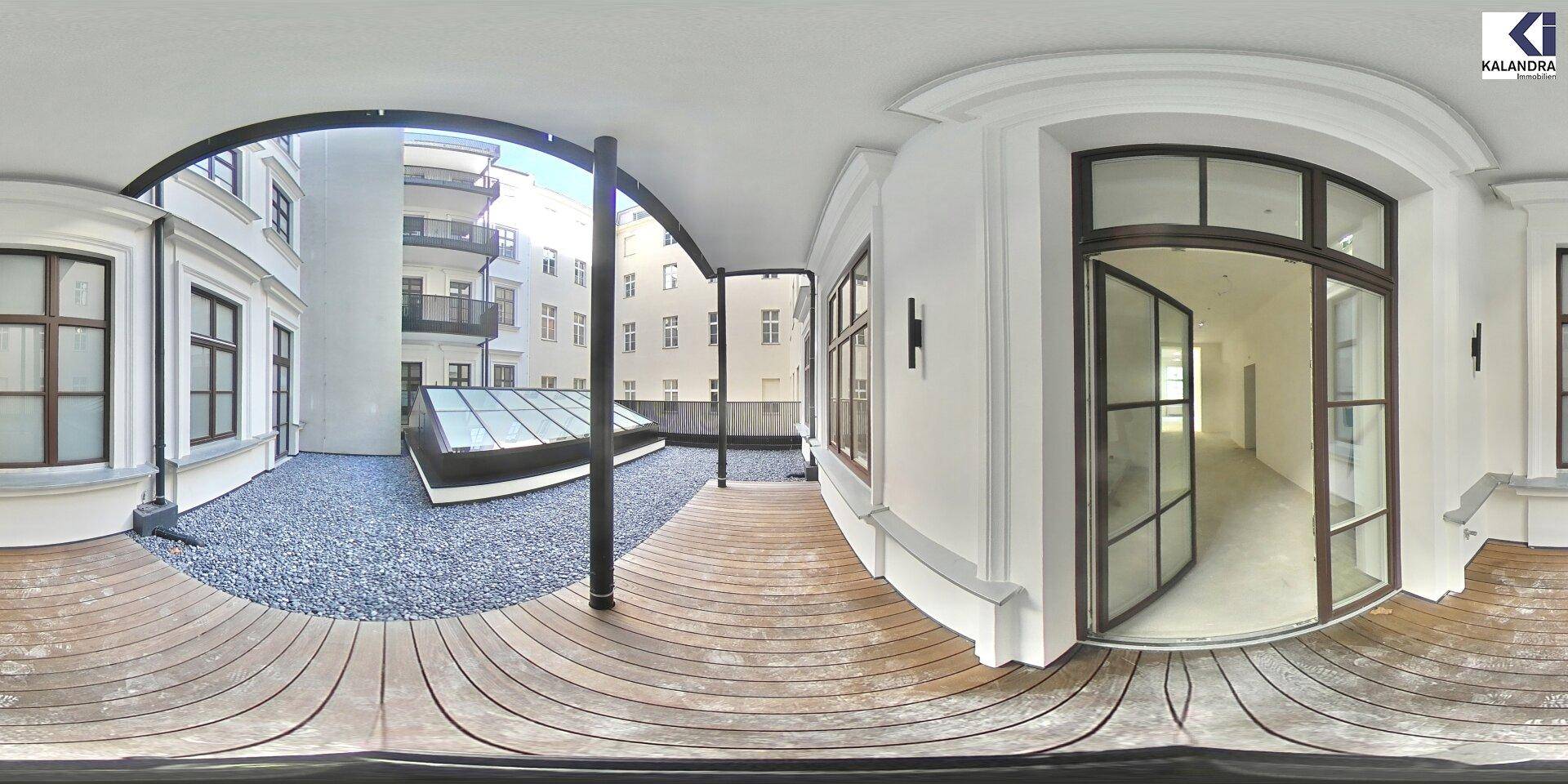 Panoramablick auf einen ruhigen Innenhof mit Holzterrasse, Kiesbereich und einem modernen Glasdach.