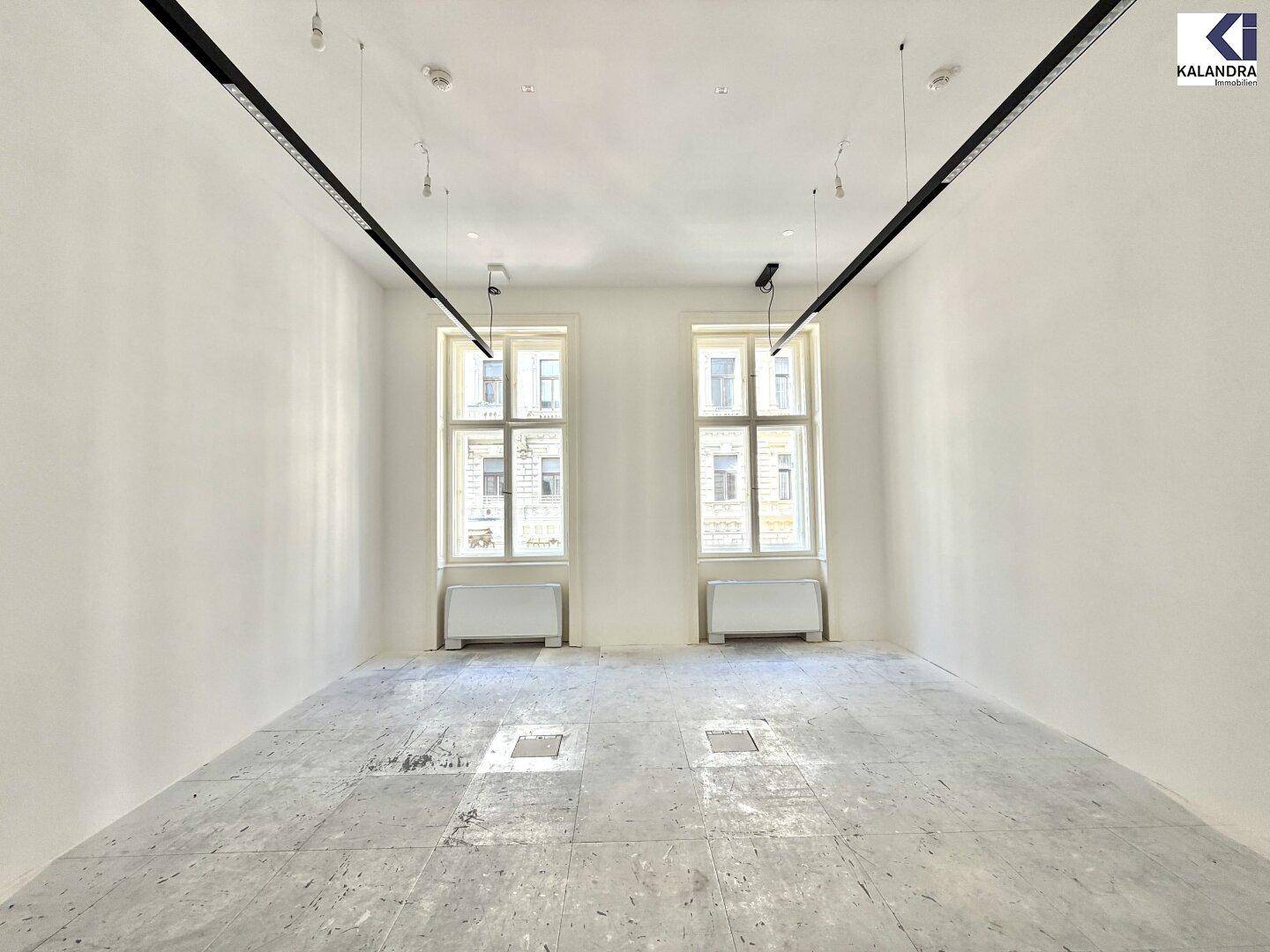 Geräumiger, heller Raum mit hohen Decken und großen Fenstern, ideal für Büroräume oder Ateliers.
