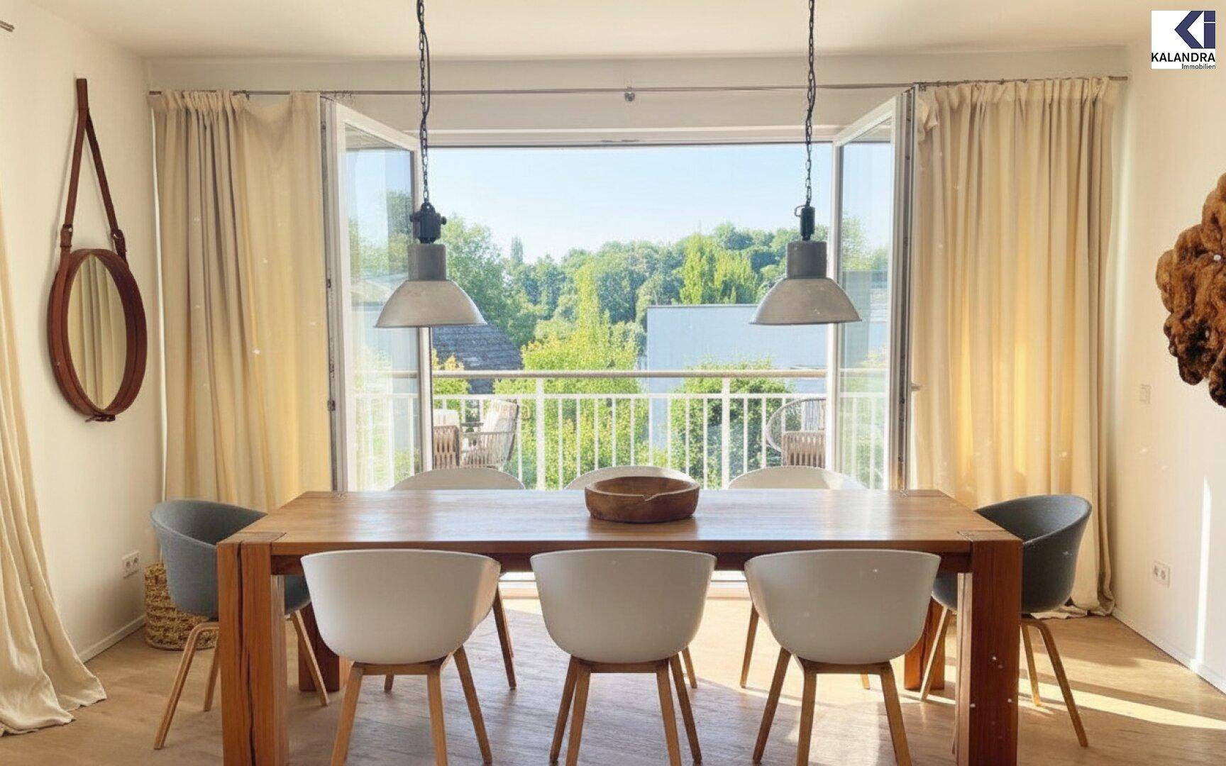 Heller Essbereich mit Holztisch, modernen Stühlen und direktem Zugang zum Balkon.