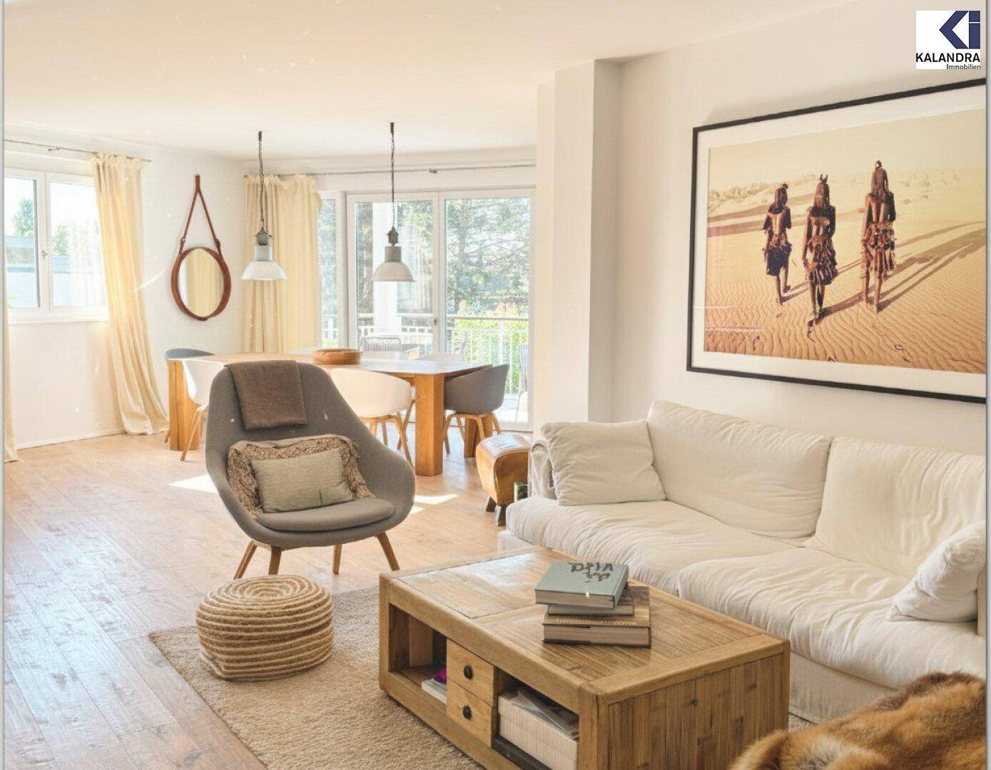 Helles Wohnzimmer mit bequemen Sofas, Holztisch und Zugang zum Balkon.