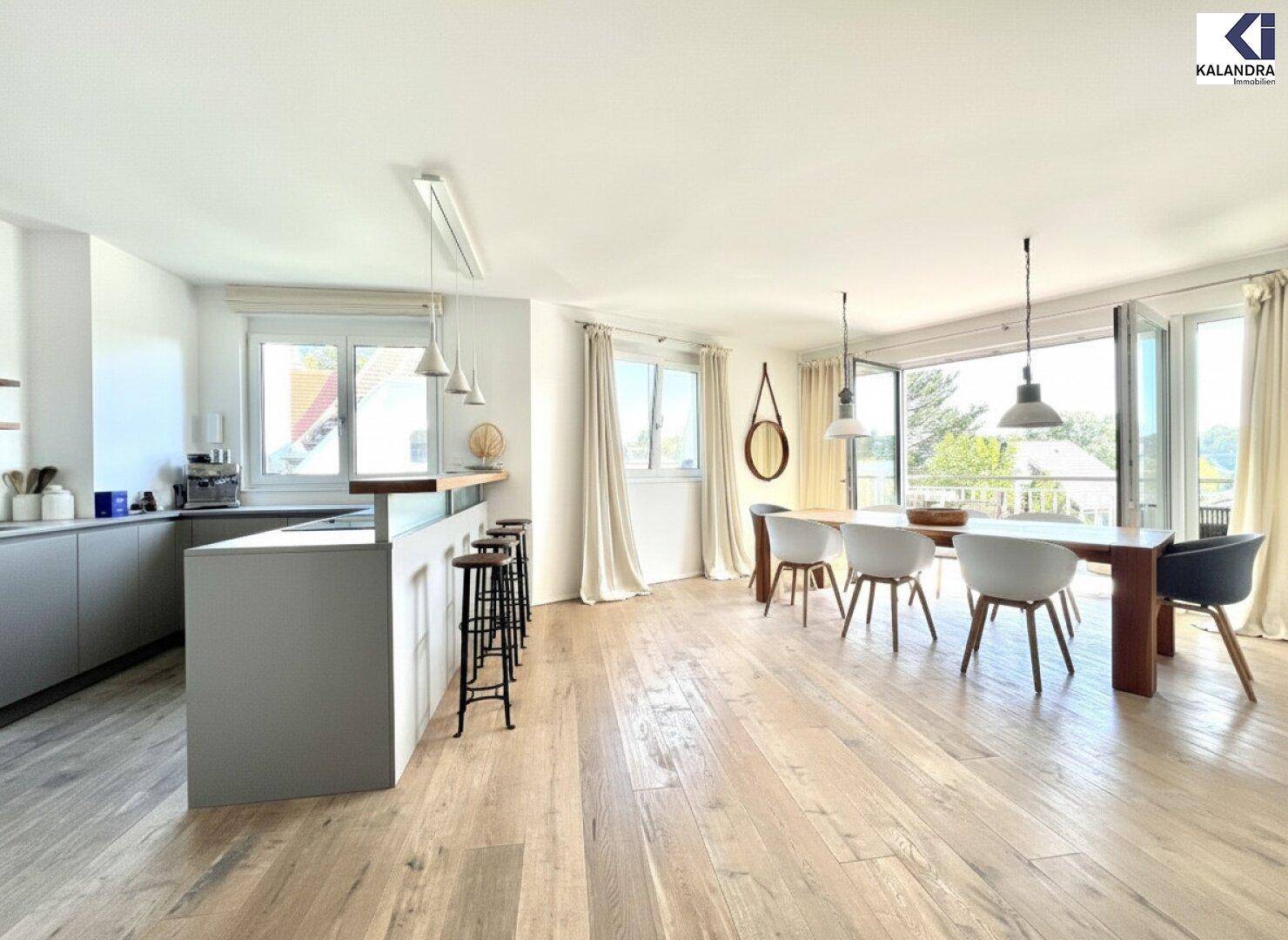 Offener Wohn- und Essbereich mit moderner Küche und Zugang zum sonnigen Balkon.