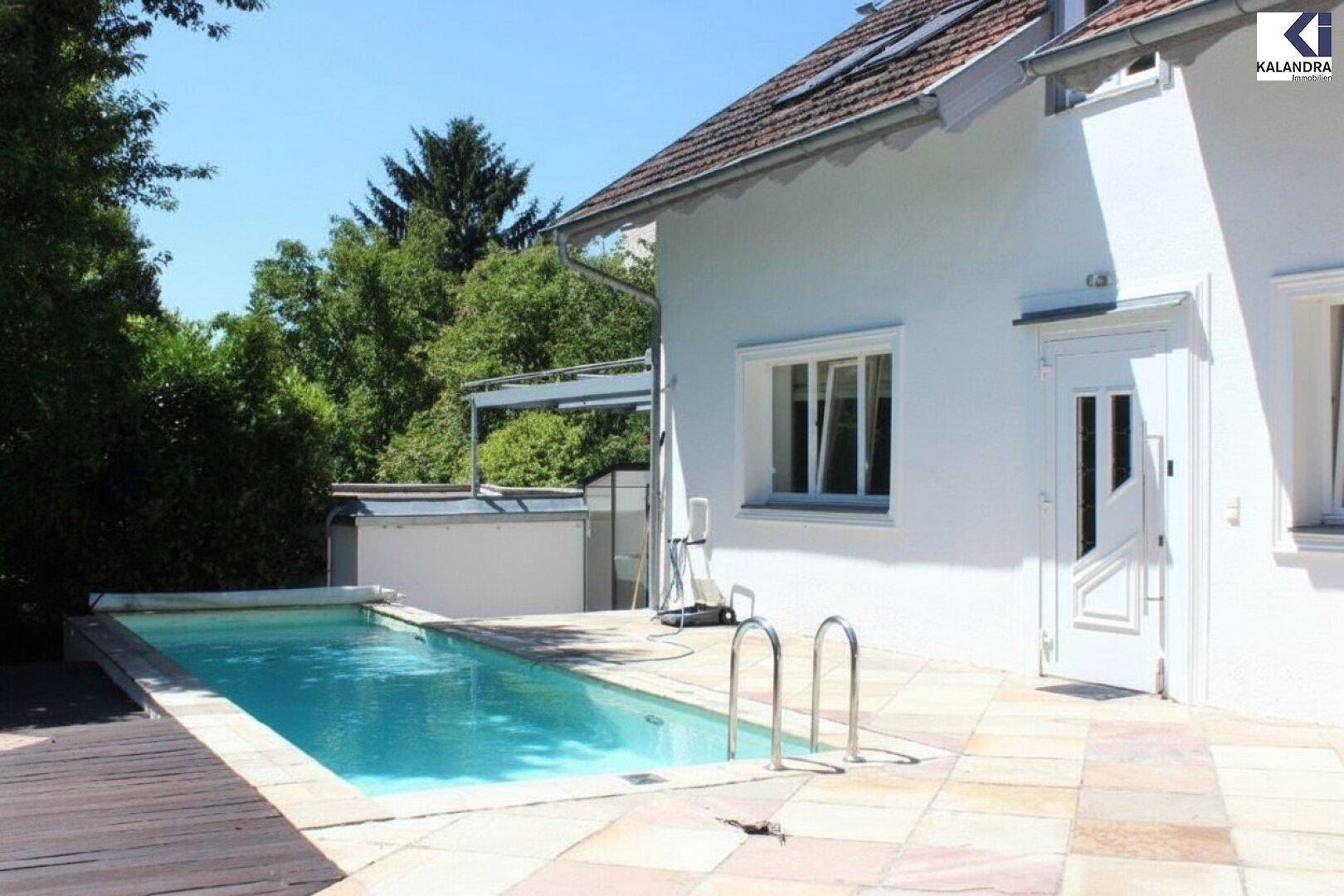 Seitliche Ansicht des Hauses mit einem schmalen Pool und einer Kombination aus Holz- und Steinterrasse.
