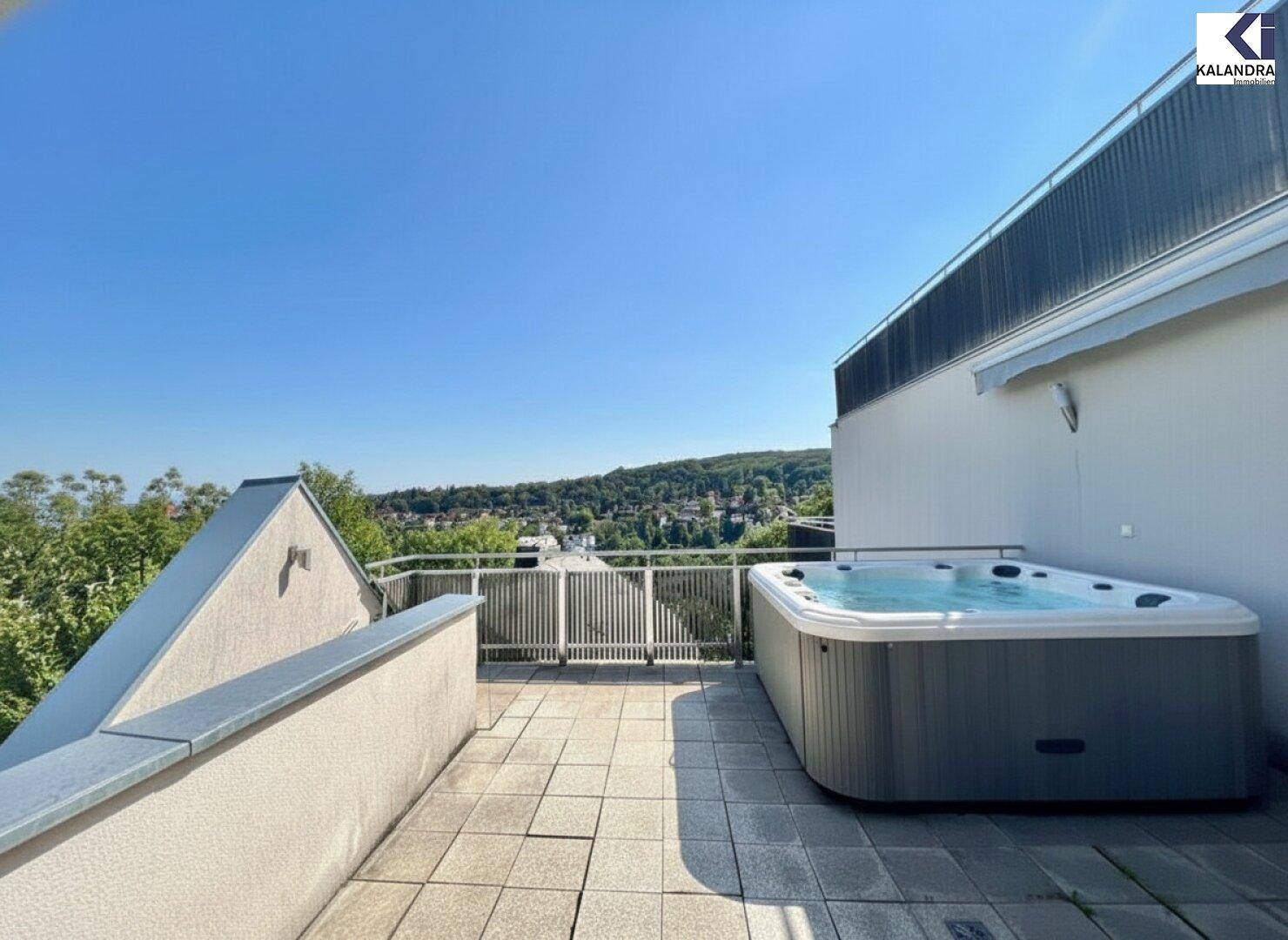 Exklusive Terrasse mit Whirlpool und Panoramablick über die umliegende Landschaft.