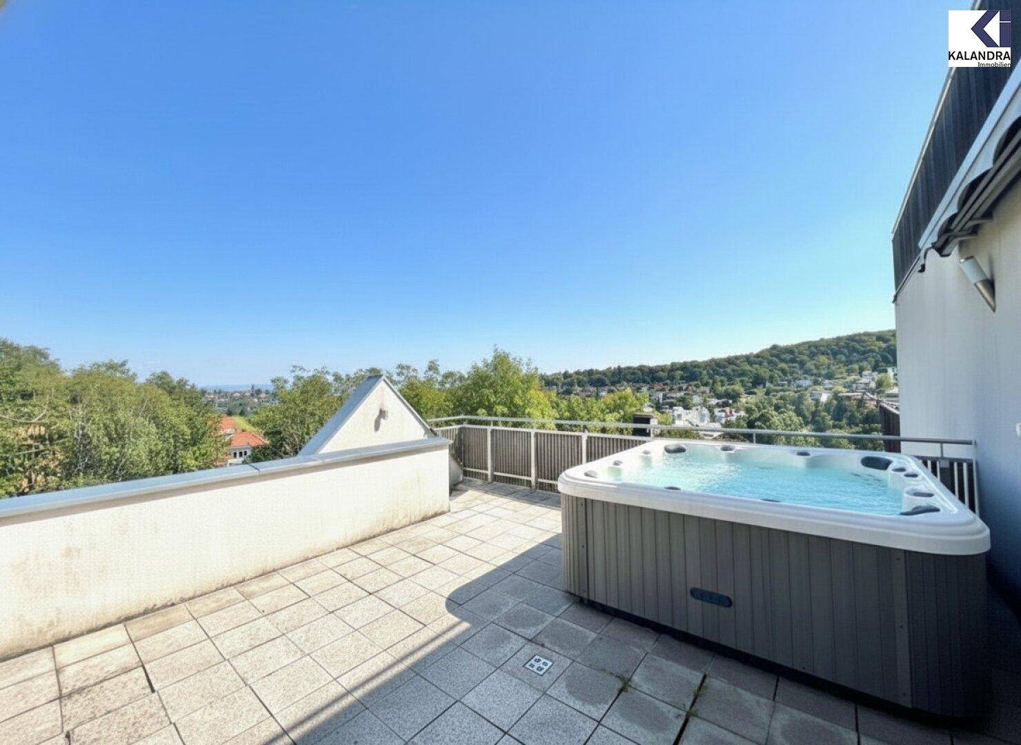 Großzügige Terrasse mit modernem Whirlpool und weitem Blick in die Natur.
