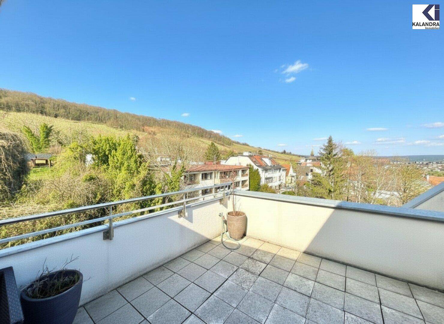 Offene Terrasse mit weitem Blick über die Landschaft und die umliegenden Häuser.
