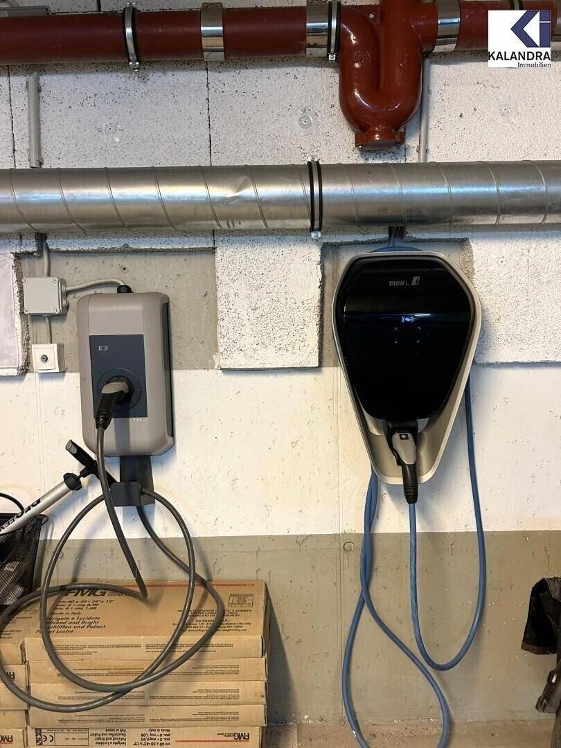 Zwei Ladestationen für Elektrofahrzeuge in einer Tiefgarage oder einem Kellerbereich.