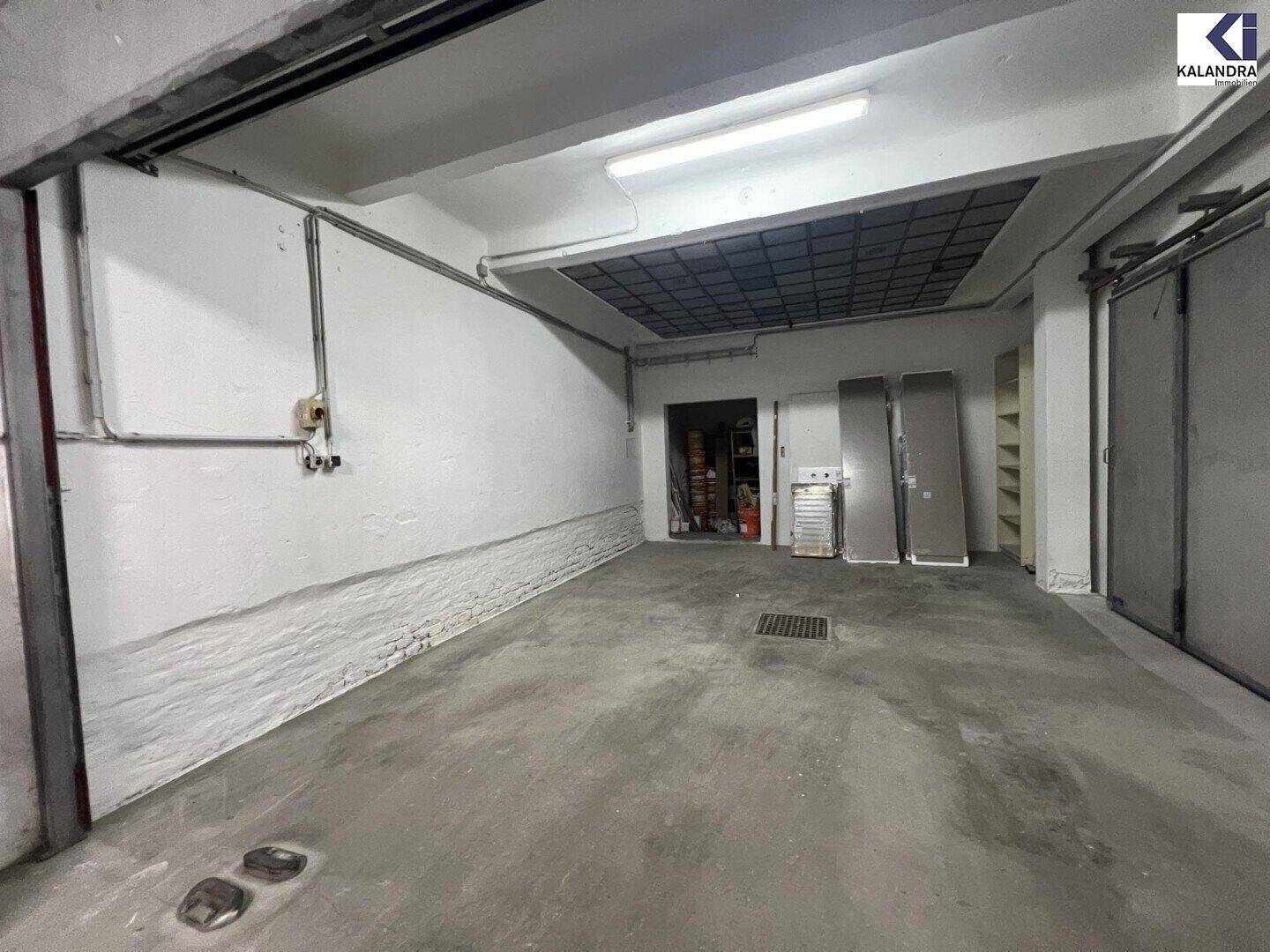 Geräumiger Garagenstellplatz mit Betonboden und einfacher Beleuchtung.