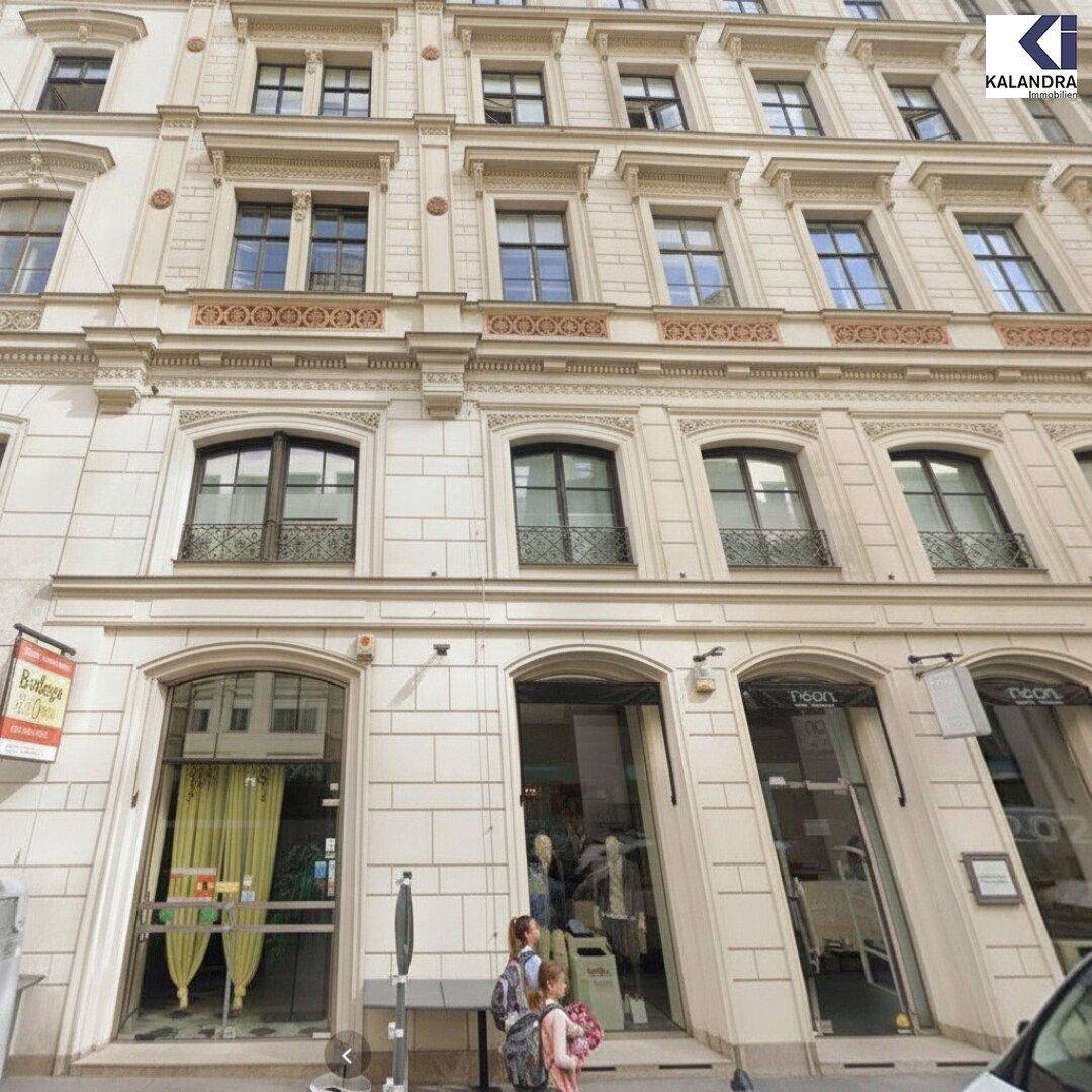 Gesamtansicht der historischen Gebäudefassade mit mehreren Etagen und Geschäften im Erdgeschoss.