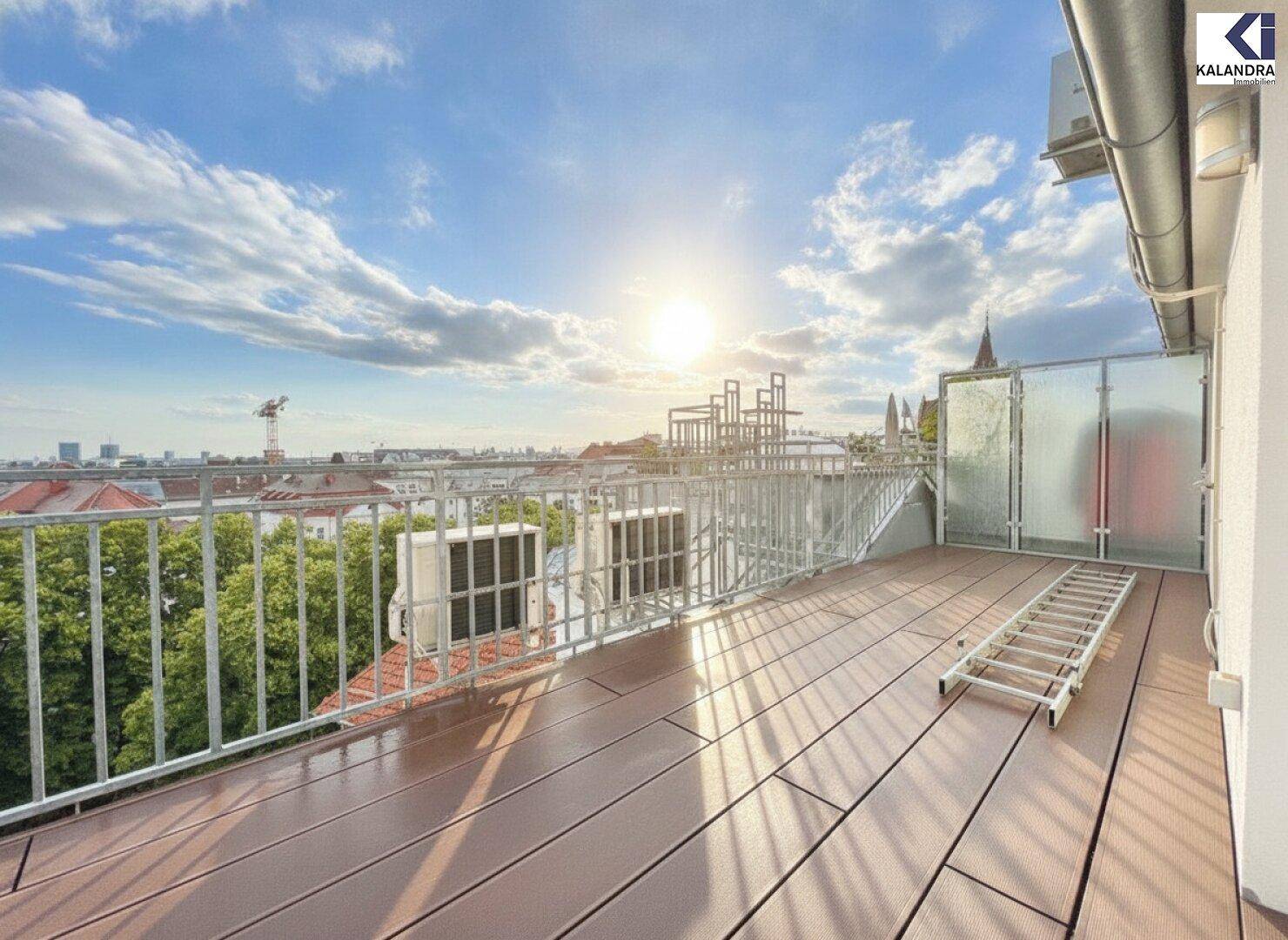 Weitläufige Dachterrasse mit Holzboden, Metallgeländer und Panoramablick über die Stadt bei Sonnenschein.