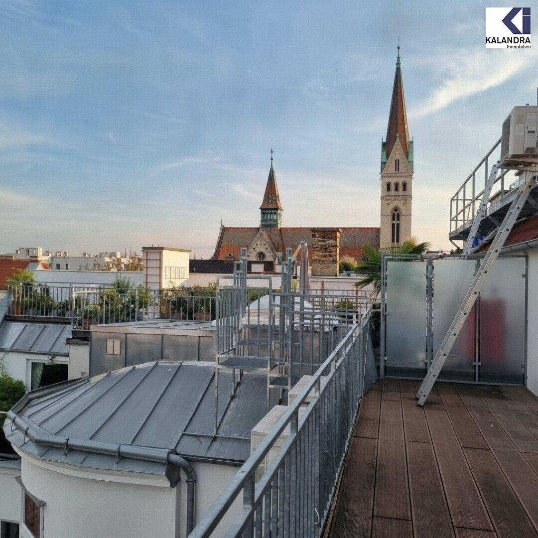 Dachbereich mit Holzboden und Metallgeländer, bietet einen Blick auf eine historische Kirche.