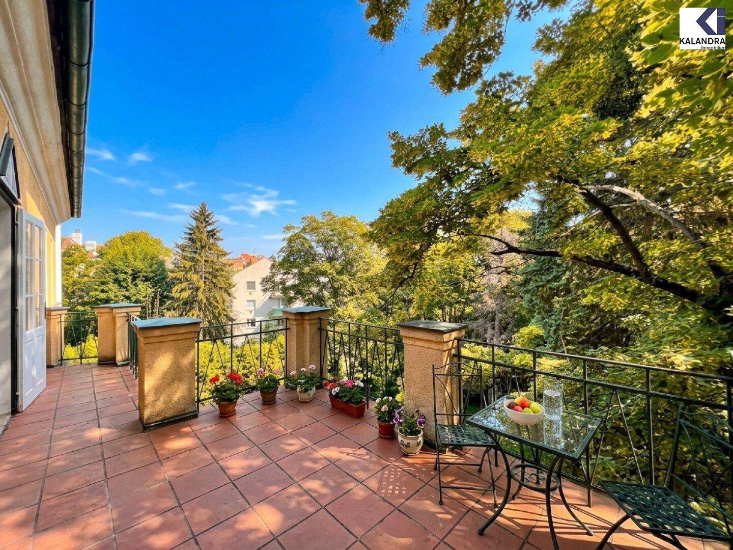 Geräumiger Balkon mit Terrakottaboden und schmiedeeisernem Geländer, bietet einen weiten Blick ins Grüne.
