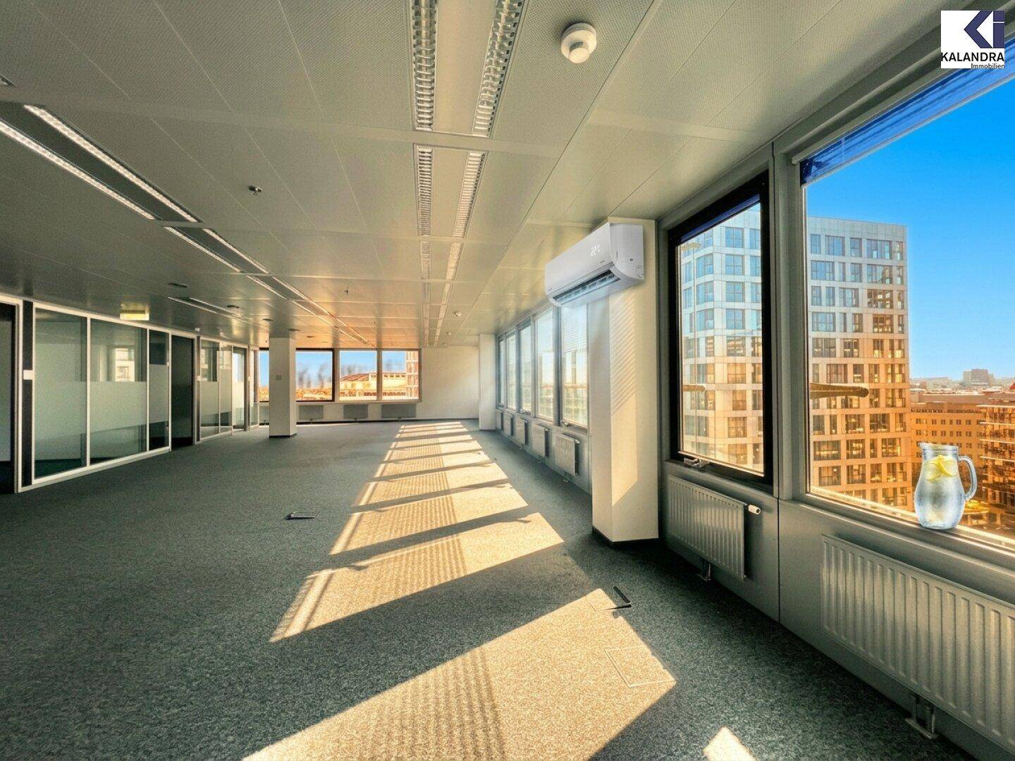 Heller Büroraum mit Teppichboden und Panoramablick auf die Stadt, ausgestattet mit Klimaanlage für Komfort.