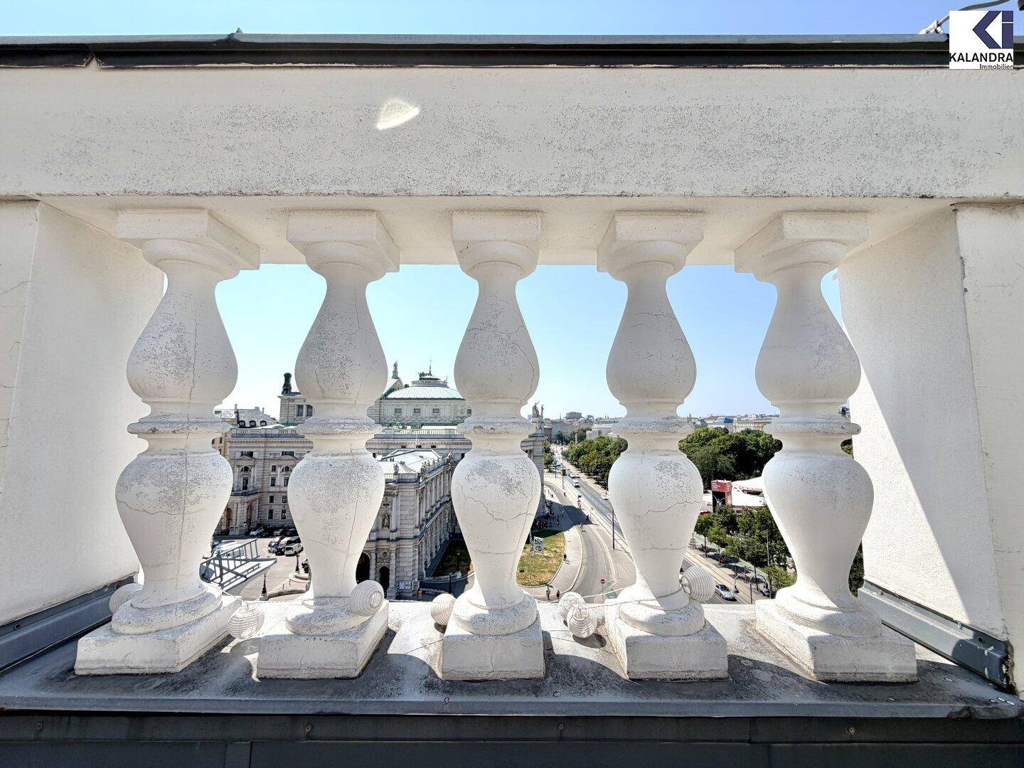 Detailansicht einer klassischen weißen Balustrade mit Blick auf die historische Stadtarchitektur im Hintergrund.