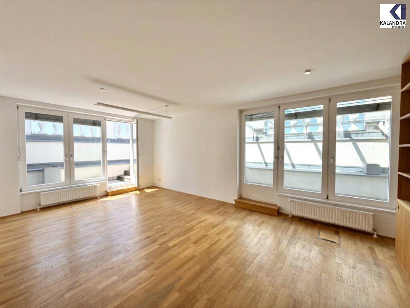 Lichtdurchfluteter Wohnraum mit Holzboden, großen Fenstern und einem eleganten Holzregal.