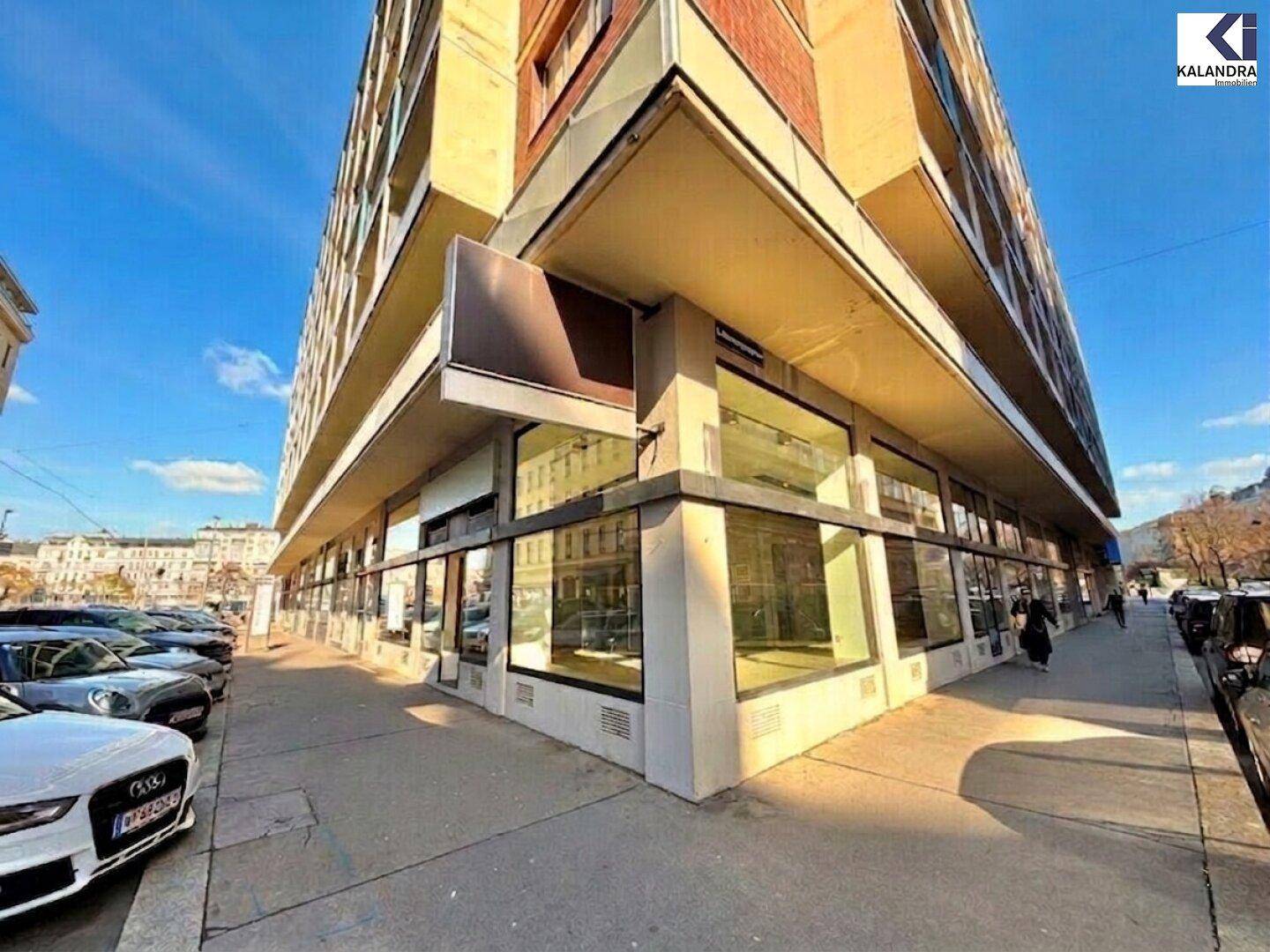 Moderne Geschäftsfassade mit großen Schaufenstern und angrenzendem Bürgersteig in städtischer Umgebung.