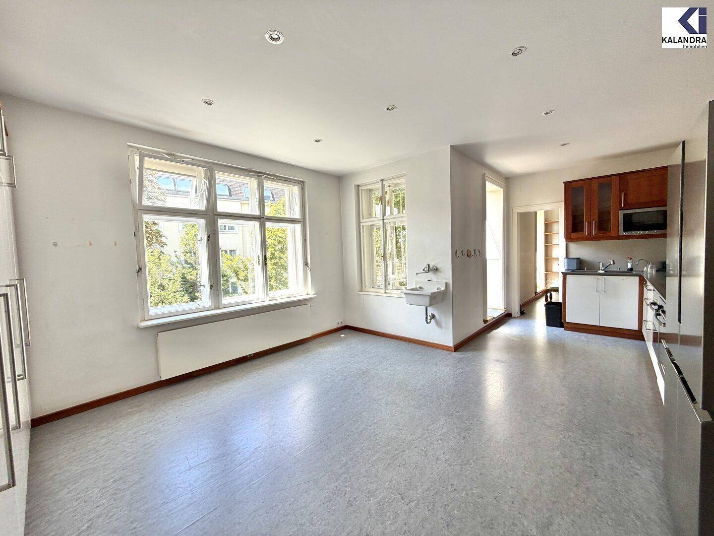 Geräumige Küche mit großen Fenstern, Spülbecken und Platz für eine Küchenzeile.