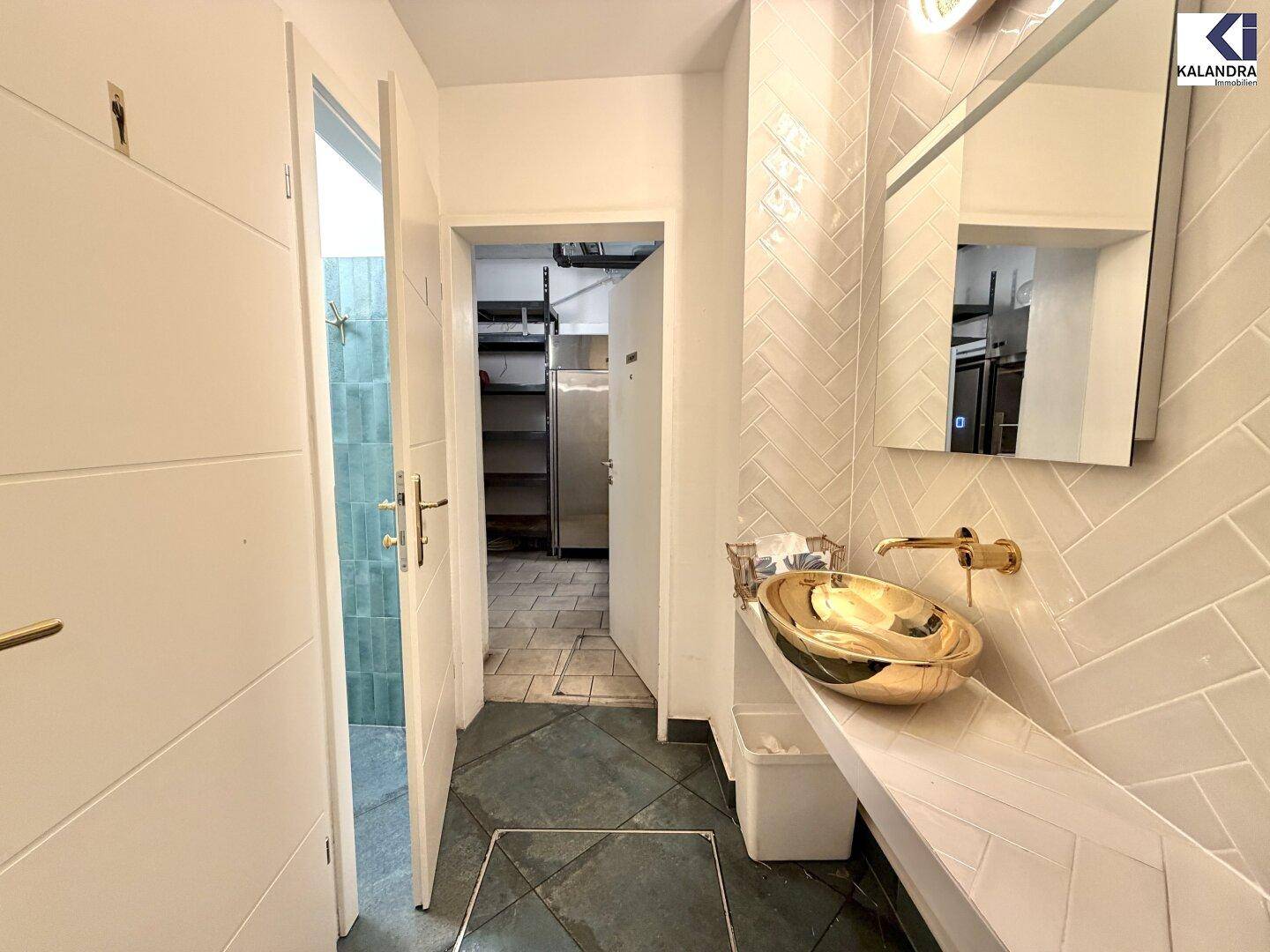 Flur mit modernem Waschbecken, Spiegel und Zugang zu weiteren Räumen, elegant gestaltet.
