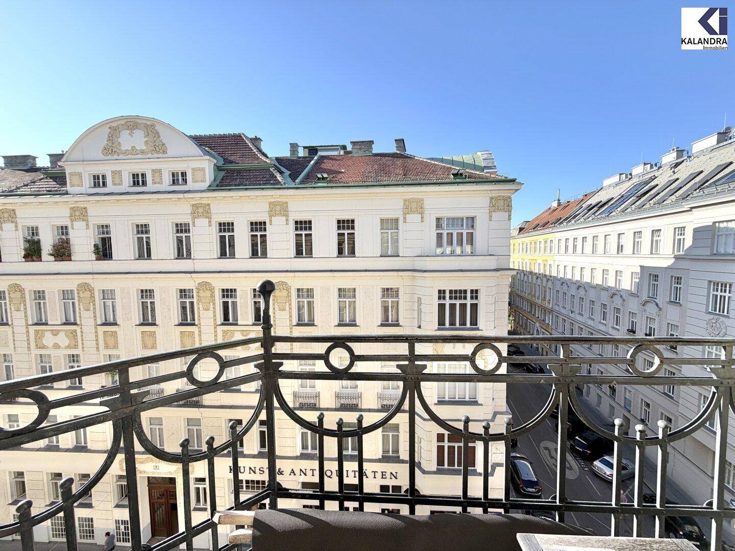 Balkon mit schmiedeeisernem Geländer und Blick auf klassische Wiener Altbauten.