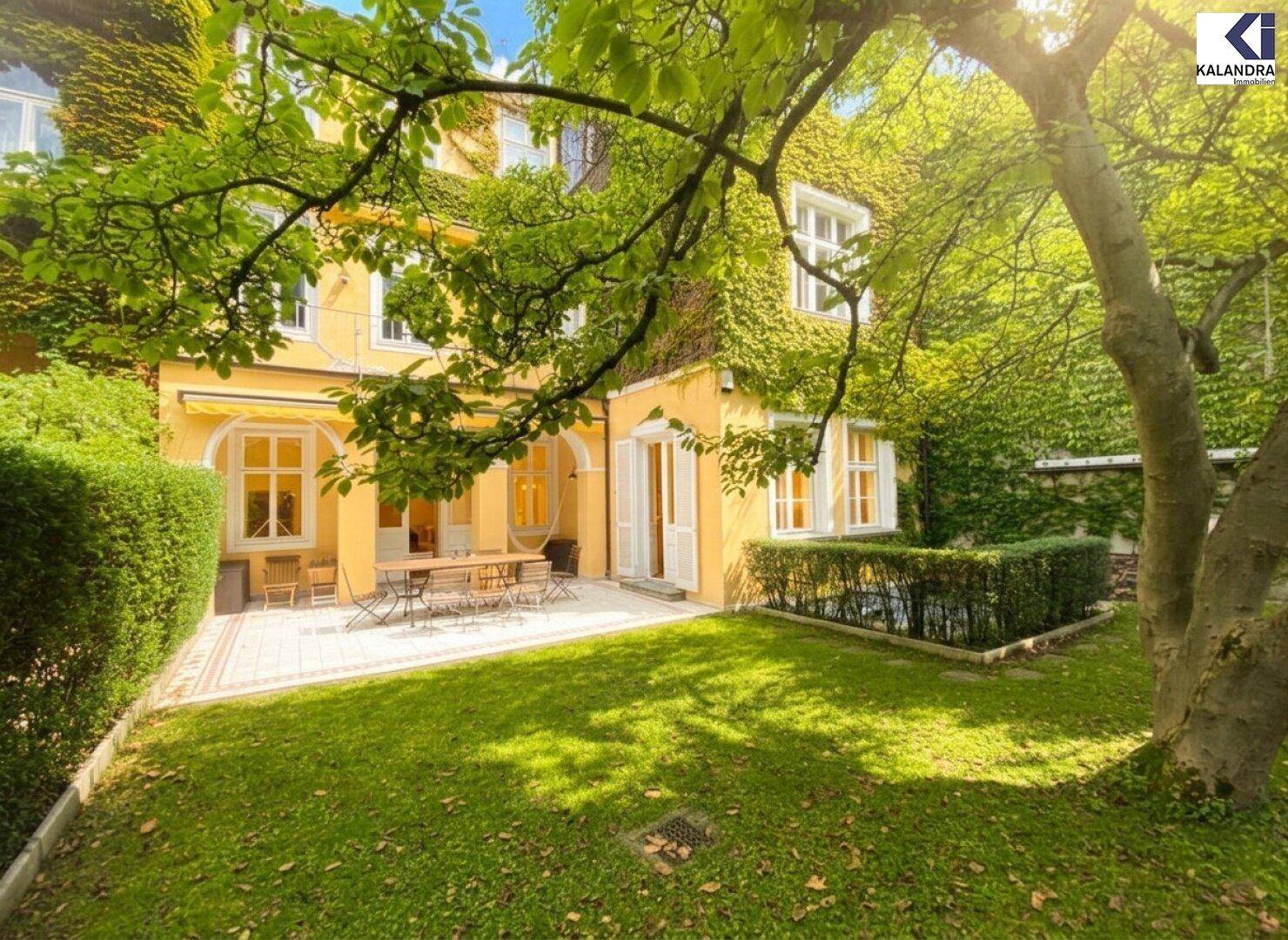 Geräumige Terrasse mit Gartenmöbeln und einem weitläufigen Rasenbereich, umgeben von üppigem Grün.