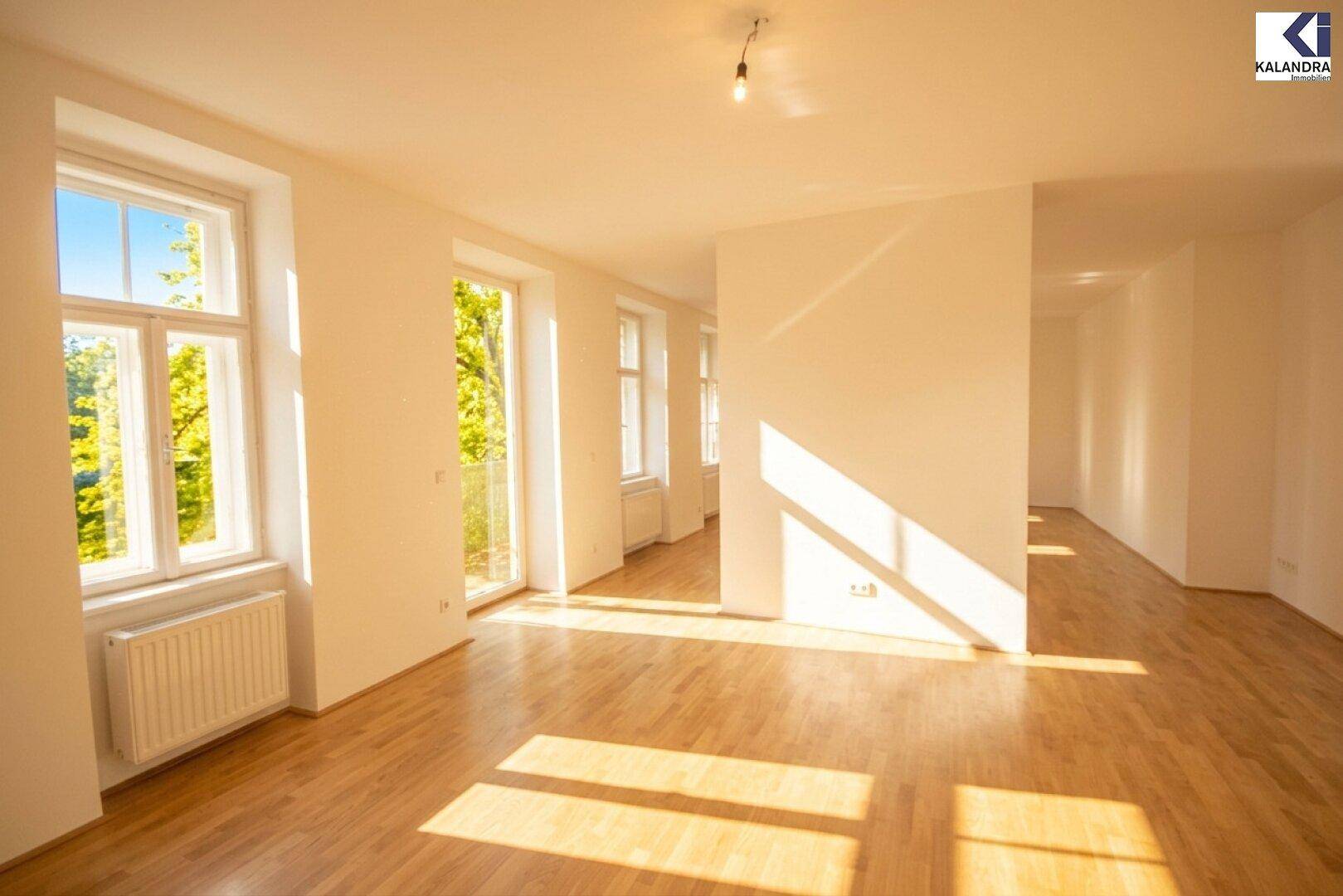 Geräumiges Wohnzimmer mit Parkettboden, großen Fenstern und viel natürlichem Lichteinfall.