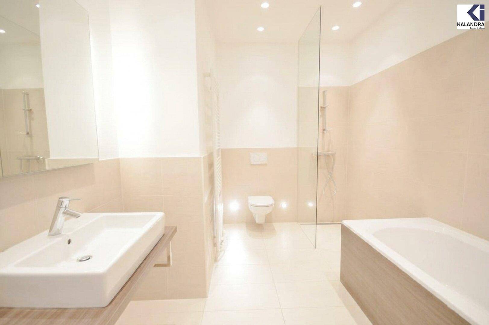 Elegantes Badezimmer mit Badewanne, Glasdusche, Wand-WC und modernem Waschtisch.