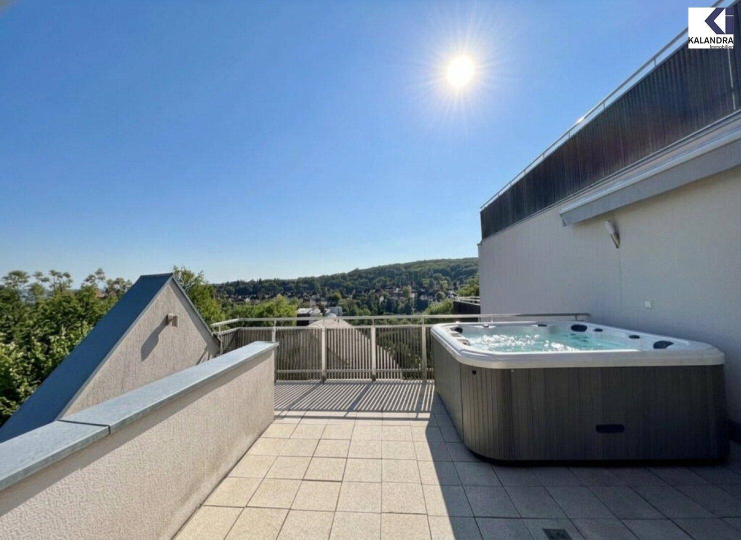 Exklusive Terrasse mit integriertem Whirlpool und Panoramablick über die Landschaft.