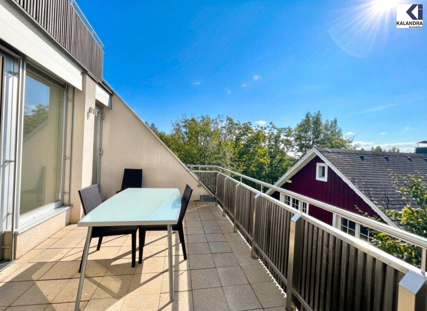 Balkon mit Esstisch und Stühlen, bietet einen angenehmen Blick auf die Umgebung.