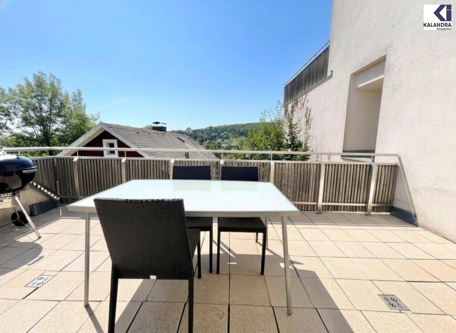 Balkon mit Esstisch, Stühlen und Grill, ideal für Mahlzeiten im Freien.