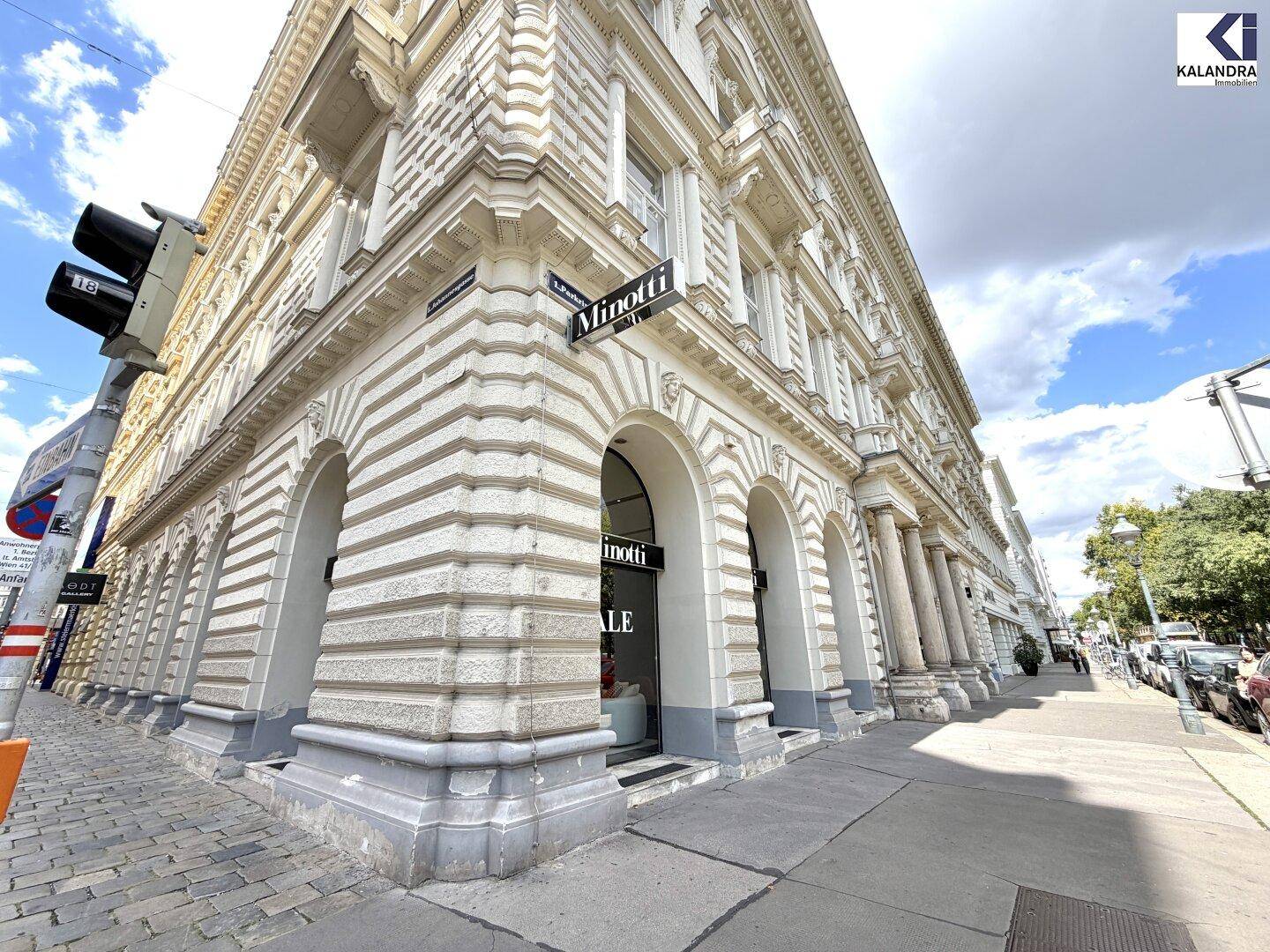 Eckansicht eines prächtigen historischen Gebäudes mit detaillierter Fassade und Geschäften im Erdgeschoss.