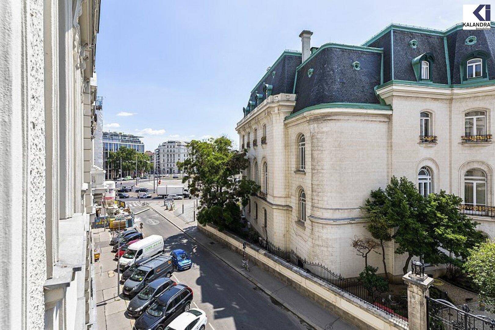 Ansicht des prächtigen Gebäudes von der Straße aus, mit geparkten Autos und umliegender Stadtarchitektur.