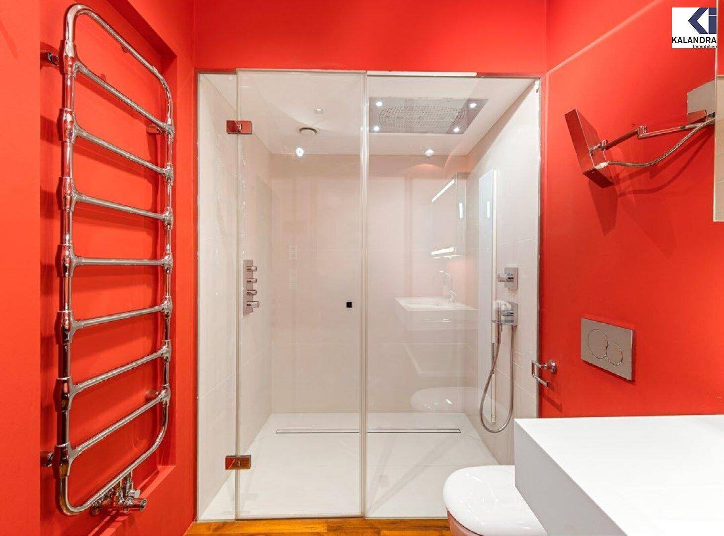 Modernes Badezimmer mit leuchtend roten Wänden, begehbarer Dusche und beheiztem Handtuchhalter.
