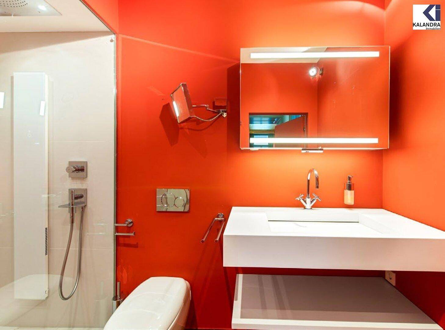Modernes Badezimmer mit leuchtend roten Wänden, wandhängendem WC und begehbarer Dusche.