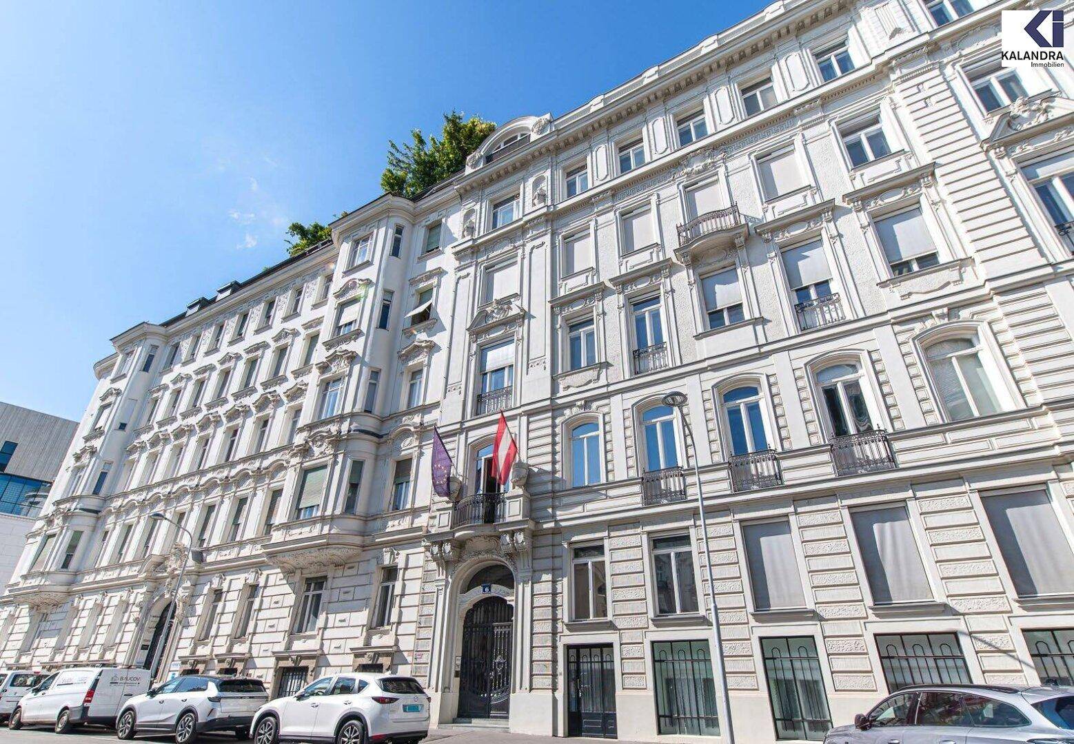 Majestätische Fassade eines historischen Gebäudes mit vielen Fenstern und Balkonen an einer Stadtstraße.