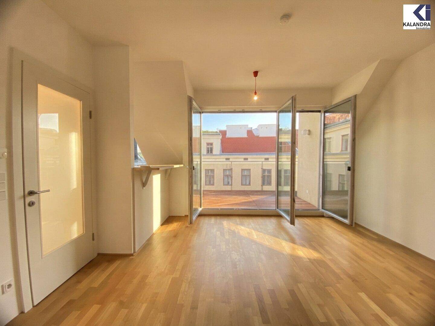 Lichtdurchfluteter Raum mit Holzboden und Zugang zum Balkon, ideal für sonnige Tage.